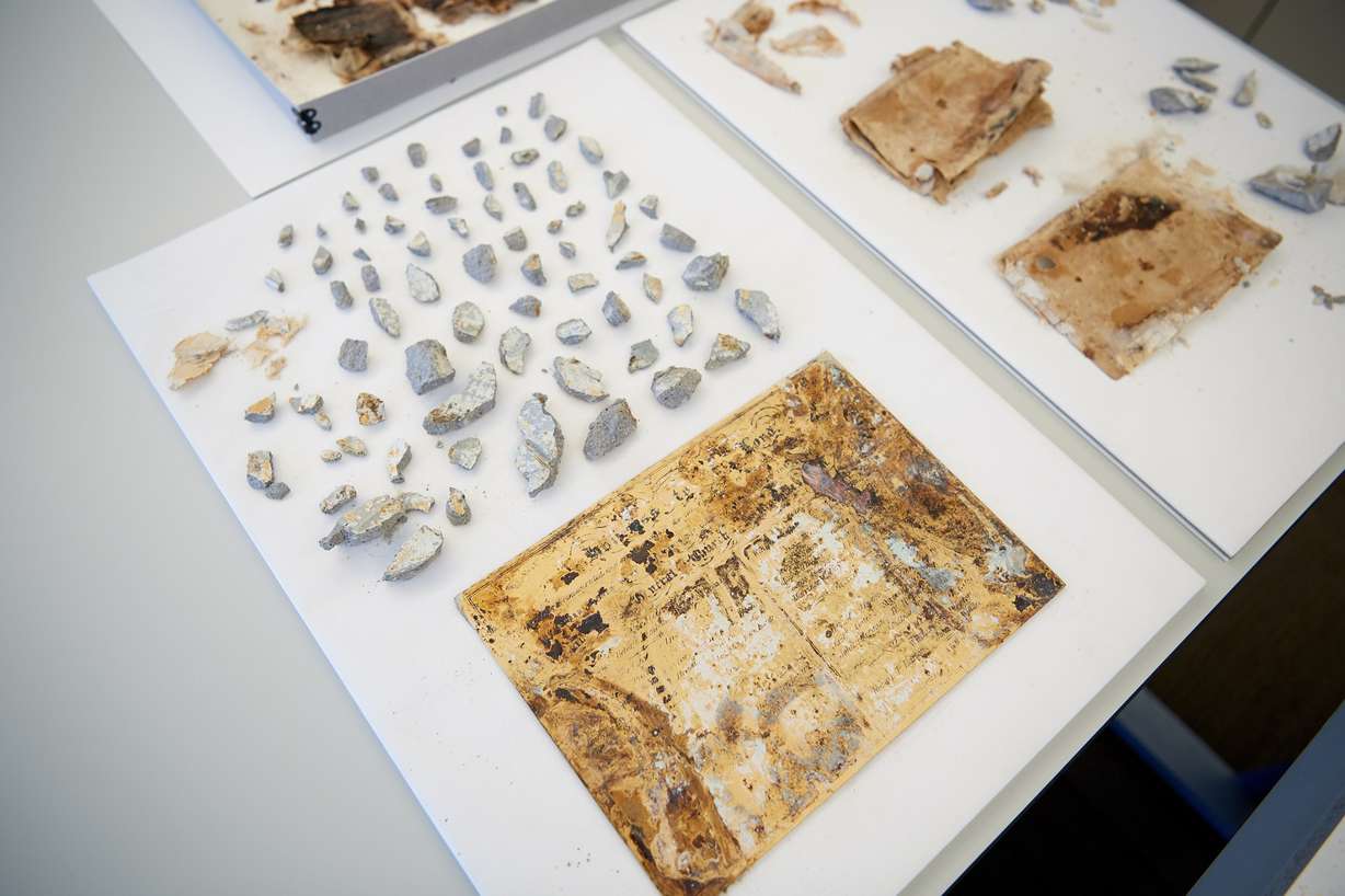Items from the capstone of the Salt Lake Temple. In the foreground, middle, is a copper plate inscribed with the names of the Church General Authorities present for the laying of the temple cornerstone on April 6, 1853, as well as the names of Church General Authorities present at the laying of the capstone on the same date 39 years later.
