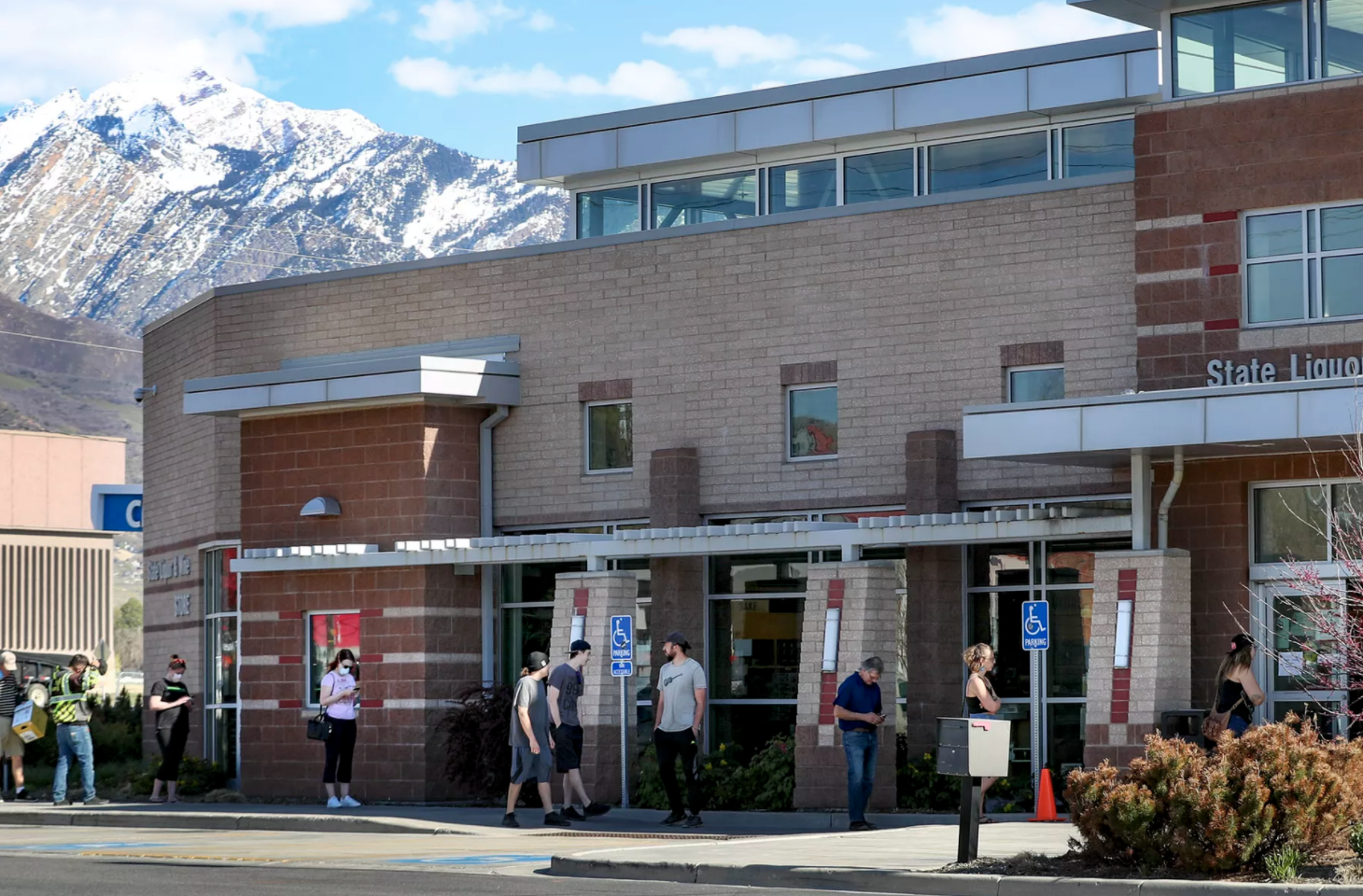 People practice social distancing as they wait in line to shop at the Utah State Liquor Store at 1814 E. Murray Holladay Road in Holladay on Tuesday, April 21, 2020.