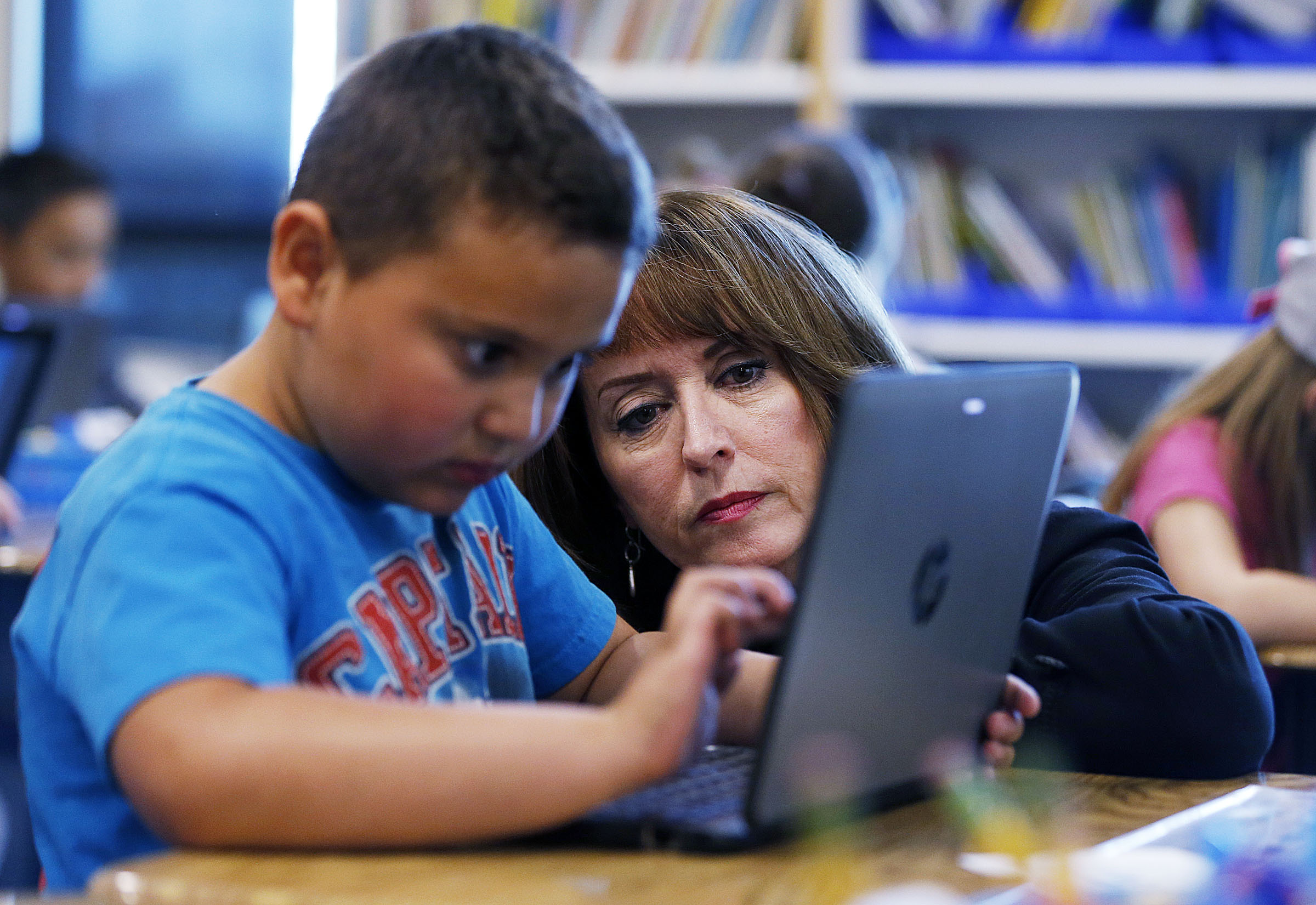Sydnee Dickson, state superintendent of public instruction, works on a laptop with first-grader Nathan during a tour of Wasatch Elementary School in Clearfield on Friday, Oct. 27, 2017.