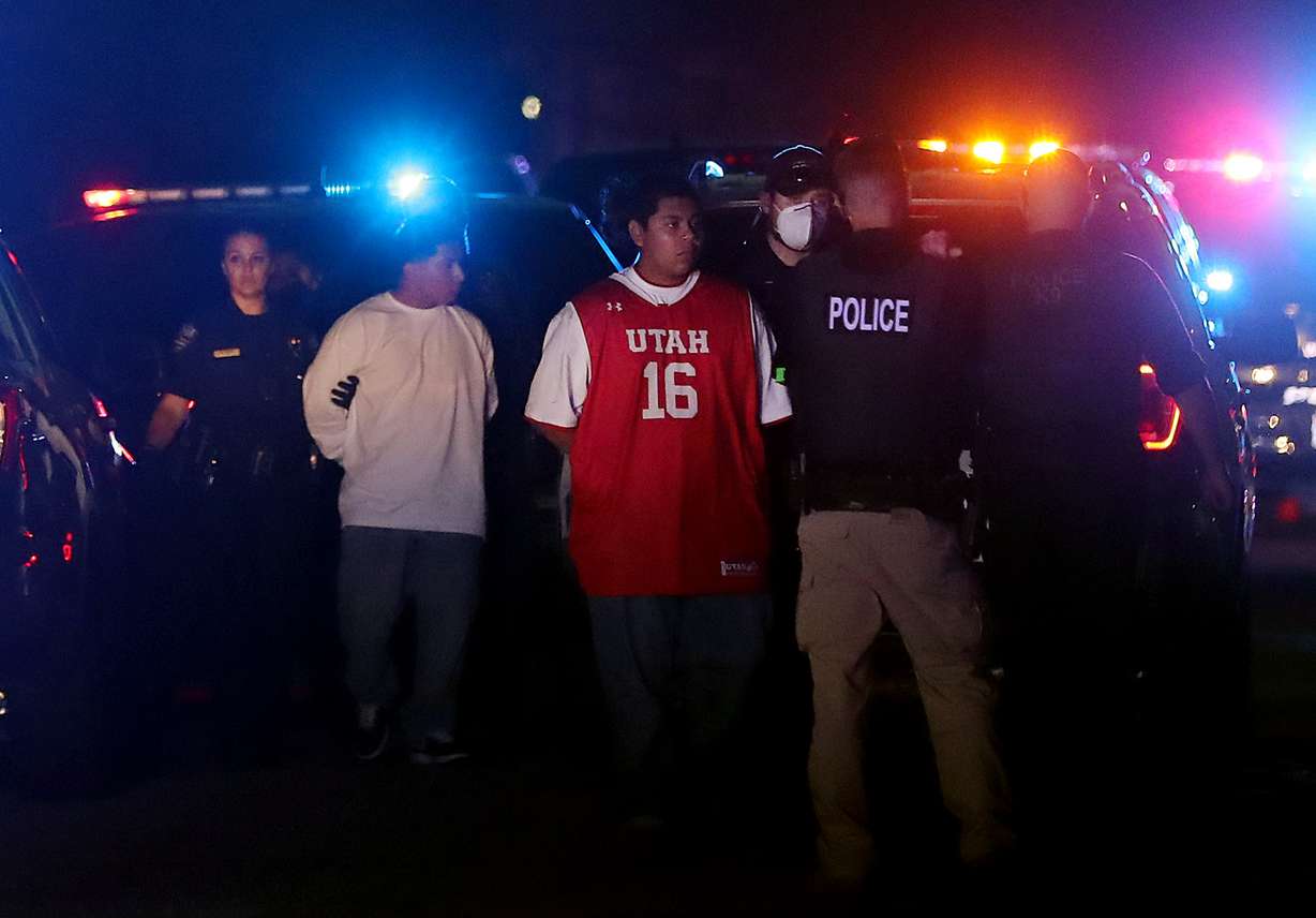 Two males are led away in handcuffs as police officers respond to an officer-involved shooting in West Jordan at 2352 W. 7680 South in West Jordan on Sunday, Aug. 2, 2020.