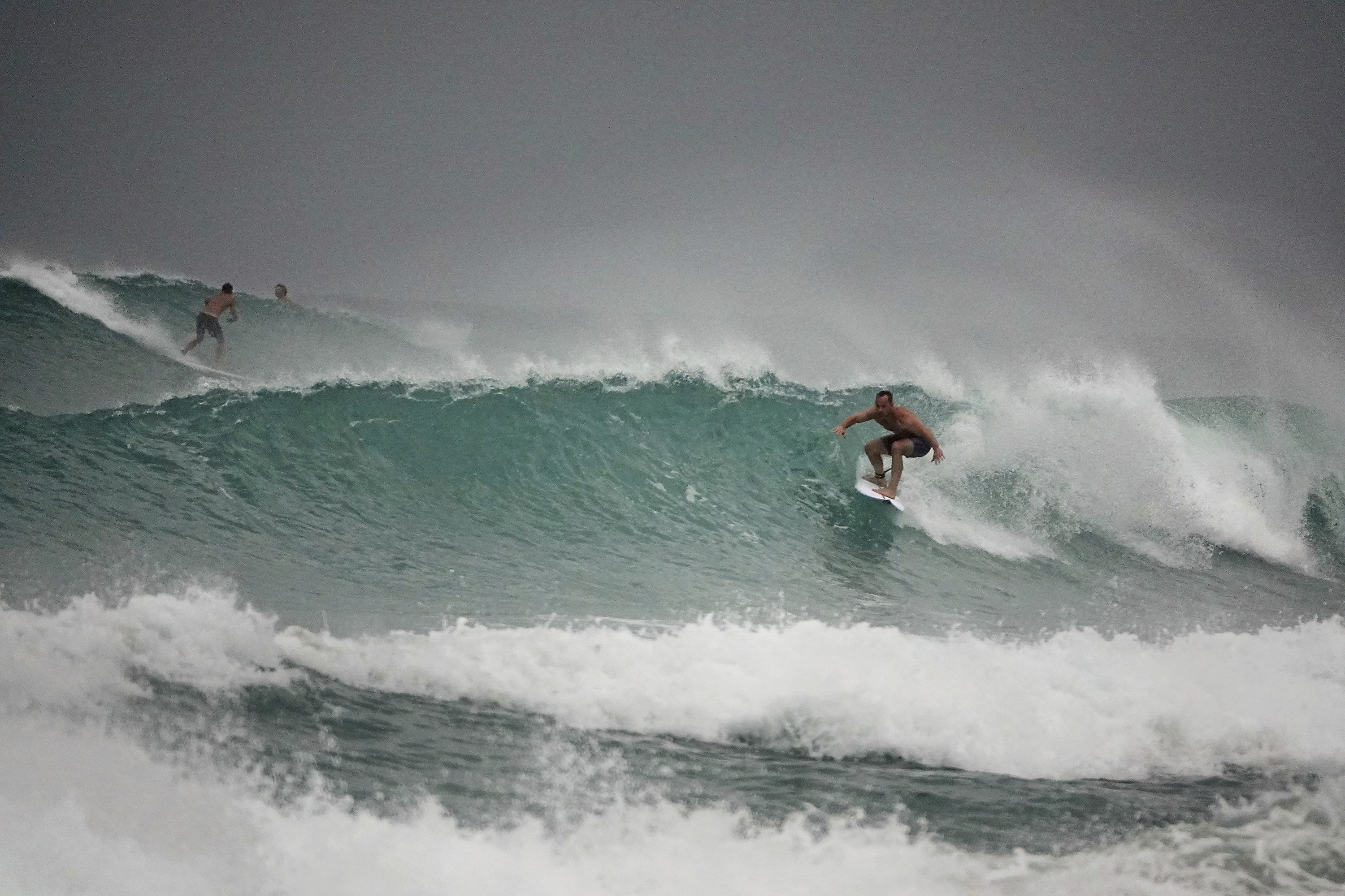 Surfers in Delray Beach enjoy the waves, Sunday, Aug. 2, 2020, as Tropical Storm Isaias brushes past the East Coast of Florida. (Joe Cavaretta, South Florida Sun-Sentinel via AP)