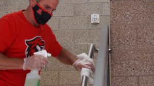 A custodian sanitizes handrails at American Fork High School Tuesday, Aug. 4, 2020.