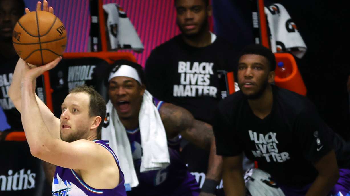 Utah Jazz's Joe Ingles, left, shoots a 3-pointer against the Memphis Grizzlies during the second half of an NBA basketball game Wednesday, Aug. 5, 2020, in Lake Buena Vista, Fla
