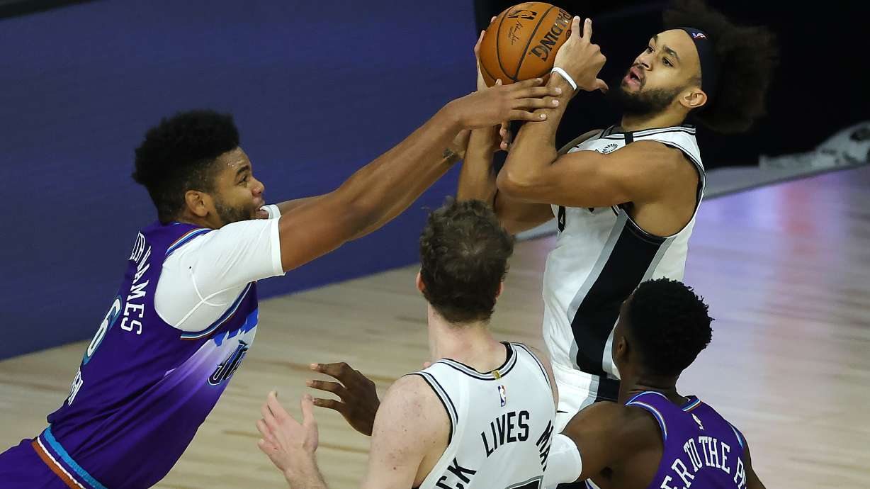 Utah Jazz' Juwan Morgan (16), fouls San Antonio Spurs' Derrick White during second half of an NBA basketball game Friday, Aug. 7, 2020, in Lake Buena Vista, Fla.