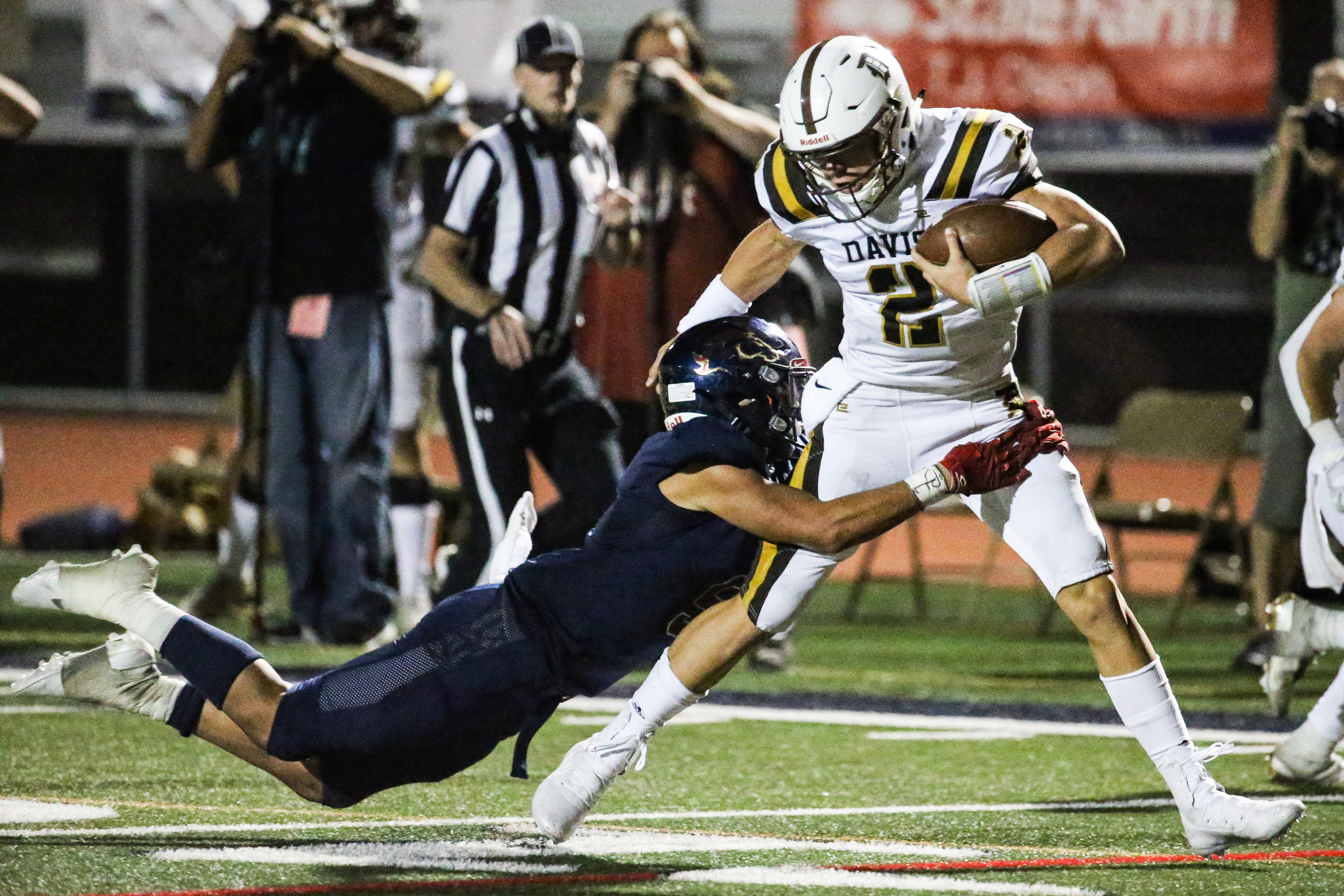 Herriman linebacker Caden Blackner (5) attempts to stop Davis quarterback Chance Trujillo (2) during a high school football game at Herriman High School in Herriman on Thursday, Aug. 13, 2020.