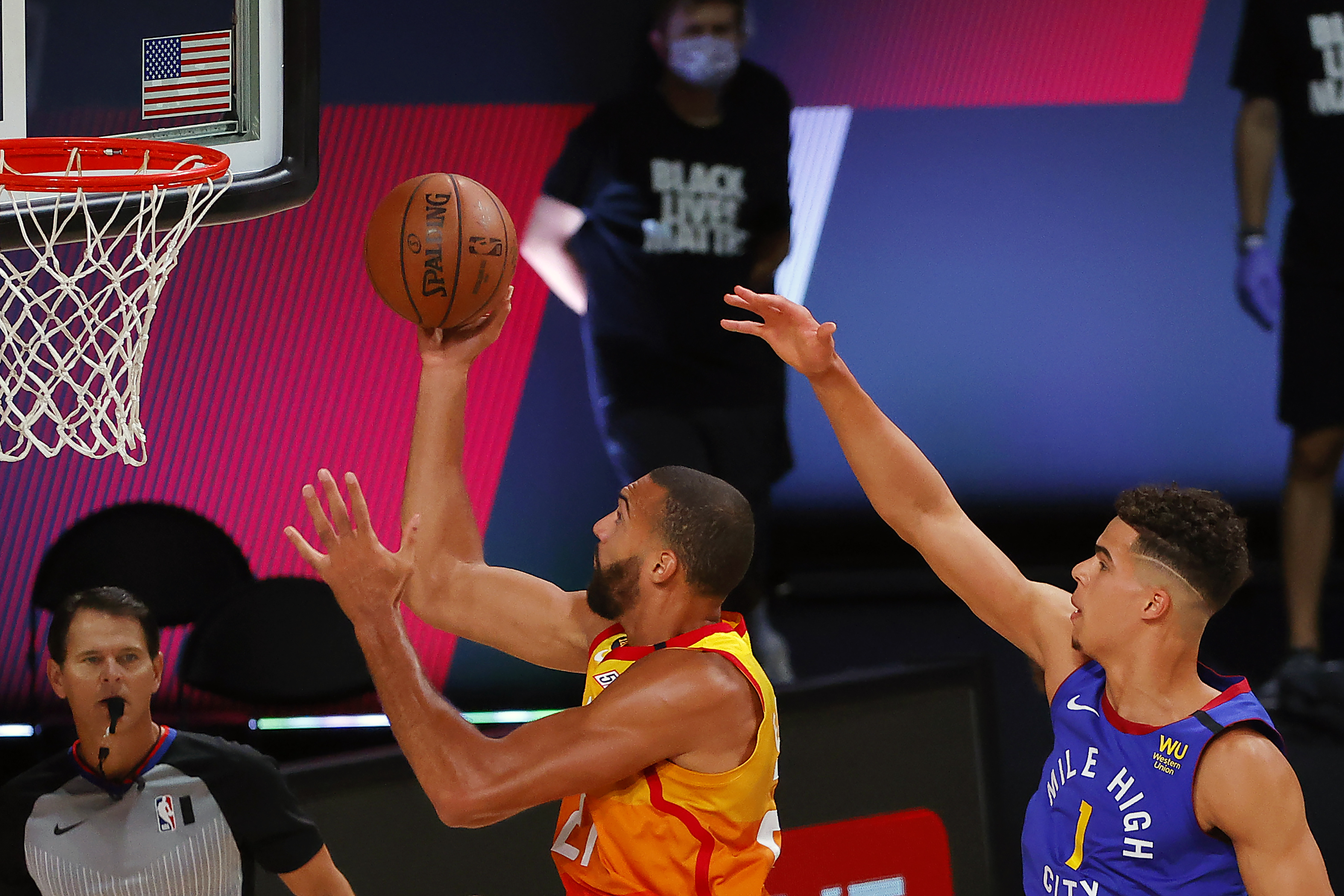 Utah Jazz' Rudy Gobert drives to the basket as Denver Nuggets' Michael Porter Jr., right, defends during the first quarter of an NBA basketball game Saturday, Aug. 8, 2020, in Lake Buena Vista, Fla. 
