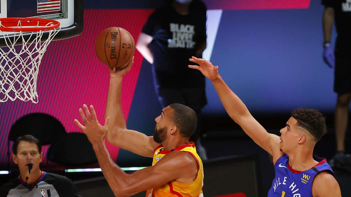 Utah Jazz' Rudy Gobert drives to the basket as Denver Nuggets' Michael Porter Jr., right, defends during the first quarter of an NBA basketball game Saturday, Aug. 8, 2020, in Lake Buena Vista, Fla.