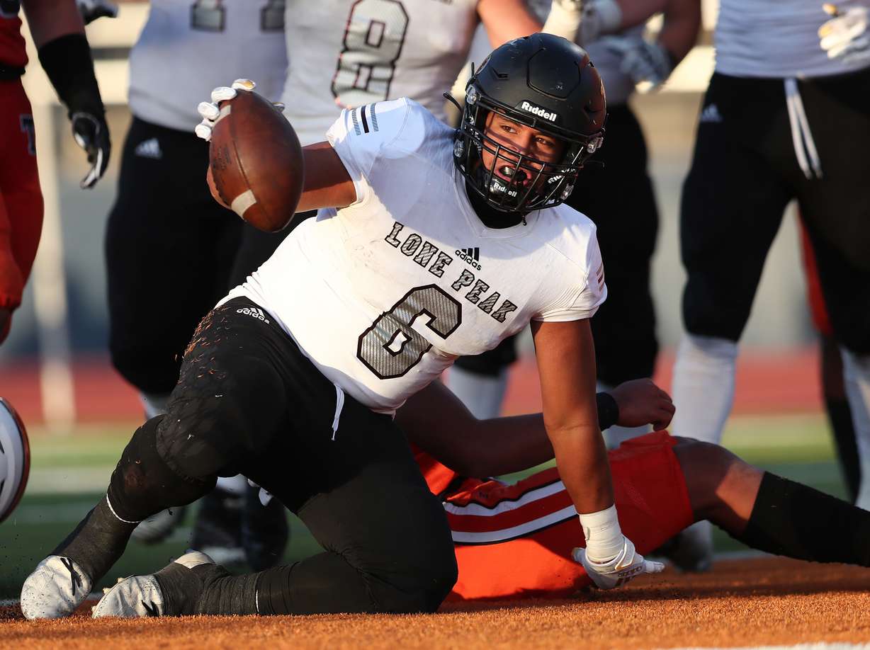 Lone Peak’s Siale Tahi gets up after scoring a touchdown as Lone Peak and Timpview play in a high school football game in Provo on Friday, Aug. 14, 2020.