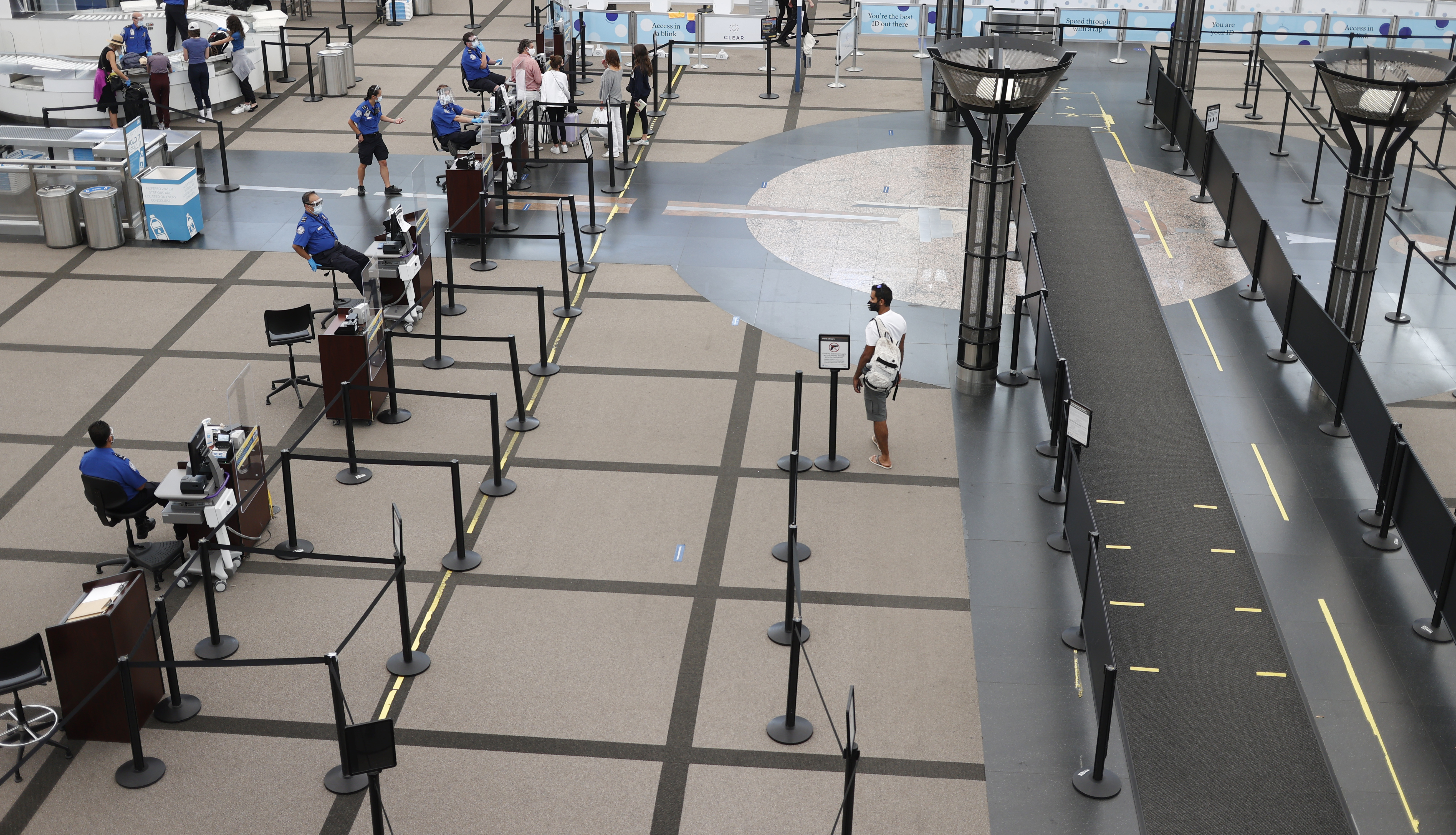 FILE - In this July 22, 2020, file photo, a lone traveler heads to the north security checkpoint in the main terminal of Denver International Airport in Denver. Airlines are trying to convince a frightened public that measures like mandatory face masks and hospital-grade air filters make sitting in a plane safer than many other indoor settings during the coronavirus pandemic, but it isn’t working. (AP Photo/David Zalubowski, File) [Aug-17-2020]