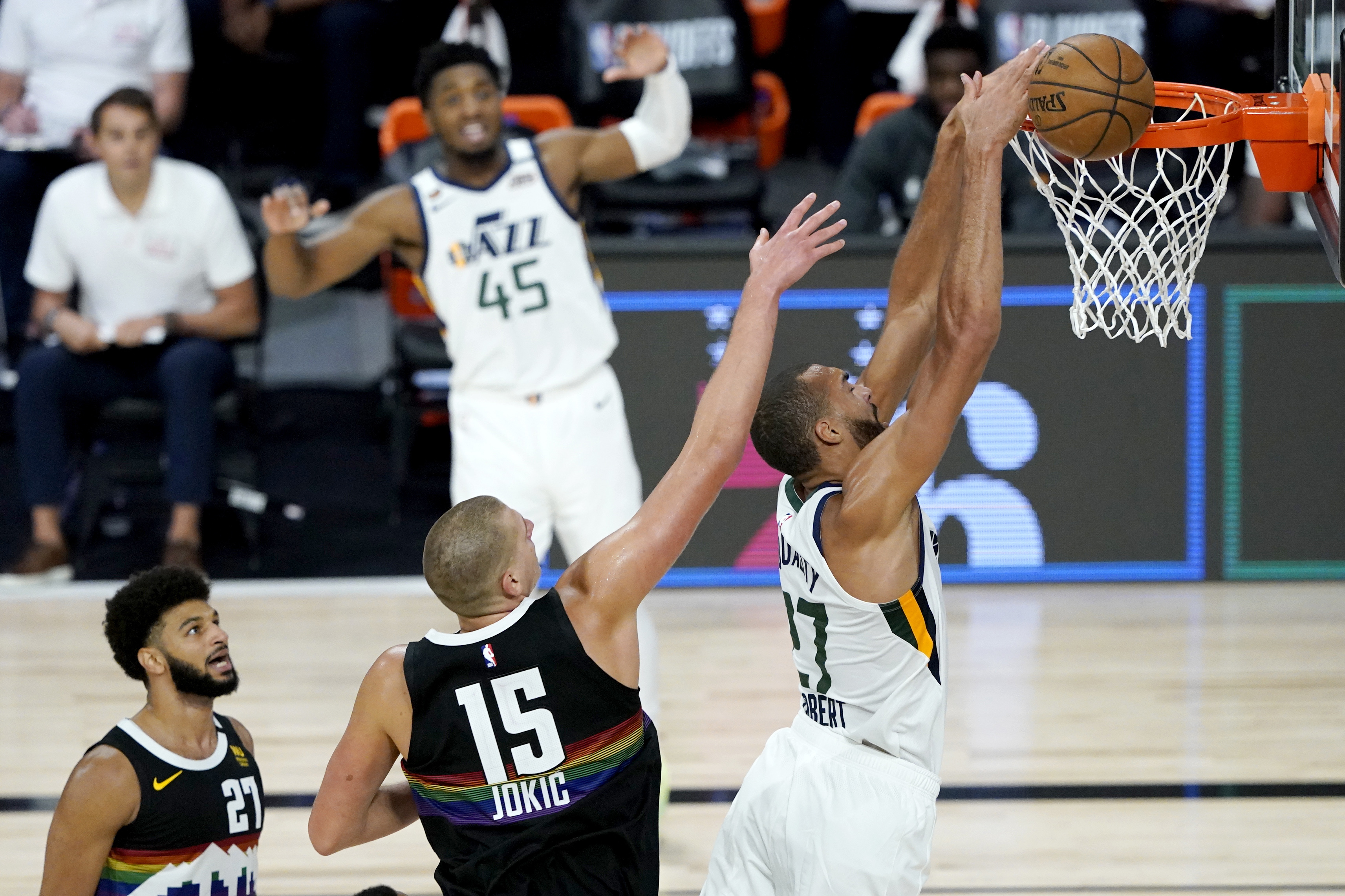 Utah Jazz's Rudy Gobert, right, misses a dunk against Denver Nuggets' Nikola Jokic (15) during the second half of an NBA basketball first round playoff game, Monday, Aug. 17, 2020, in Lake Buena Vista, Fla. Nuggets' Jamal Murray (27) and Jazz's Donovan Mitchell (45) look on during the play.