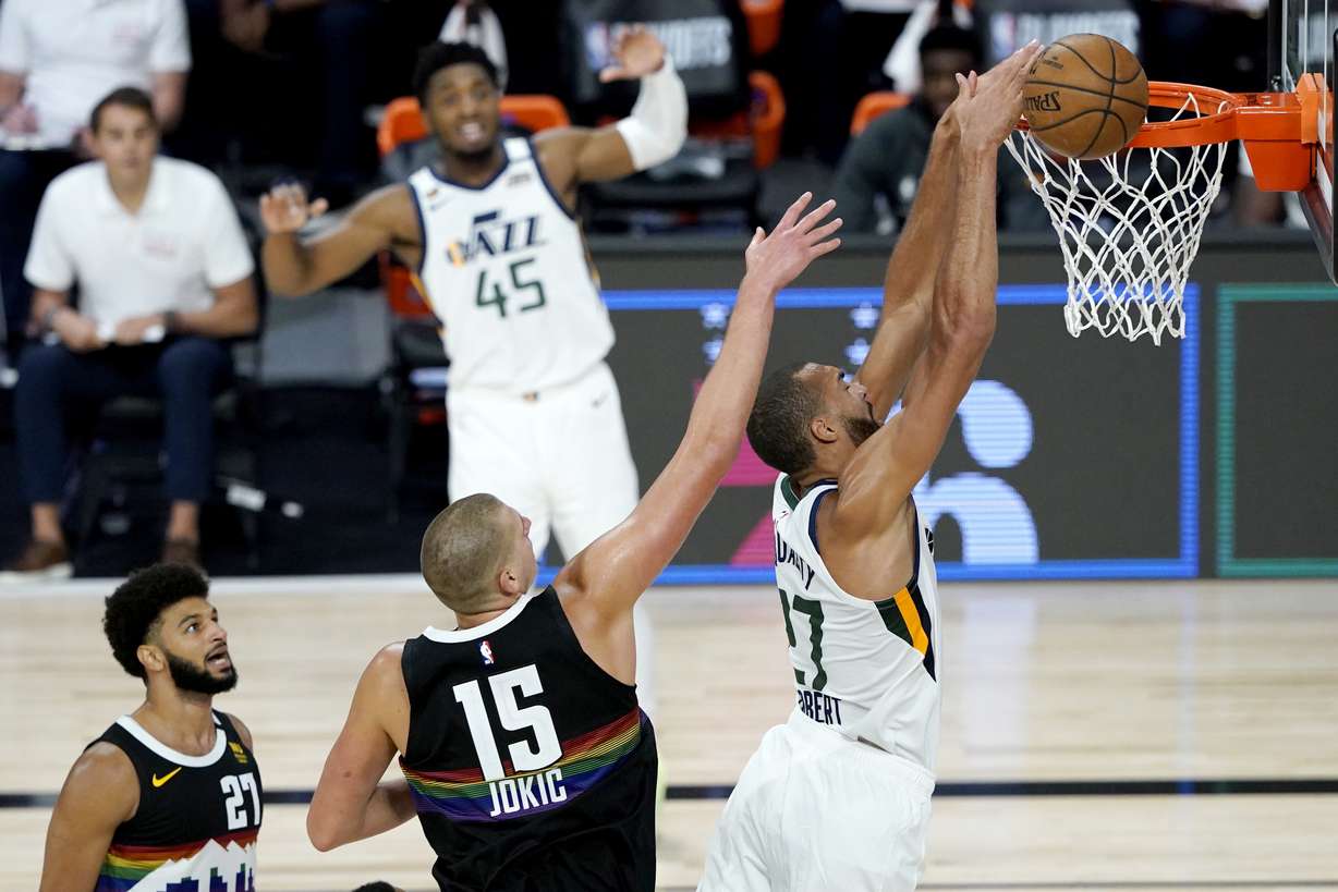 Utah Jazz's Rudy Gobert, right, misses a dunk against Denver Nuggets' Nikola Jokic (15) during the second half of an NBA basketball first round playoff game, Monday, Aug. 17, 2020, in Lake Buena Vista, Fla. Nuggets' Jamal Murray (27) and Jazz's Donovan Mitchell (45) look on during the play.