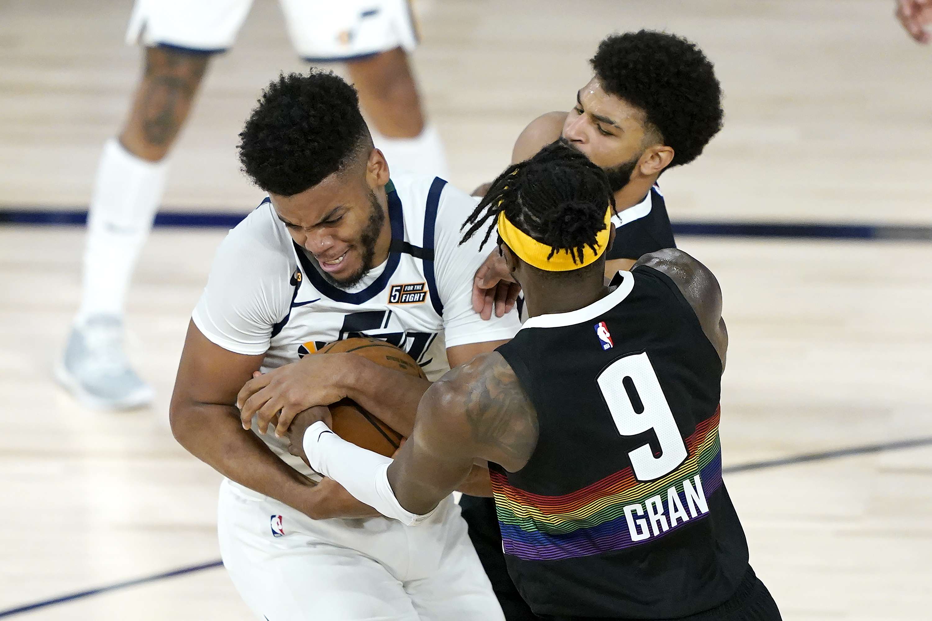 Utah Jazz's Juwan Morgan, left, scrambles for the ball with Denver Nuggets' Jerami Grant (9) and Jamal Murray during the second half of an NBA basketball first round playoff game, Monday, Aug. 17, 2020, in Lake Buena Vista, Fla