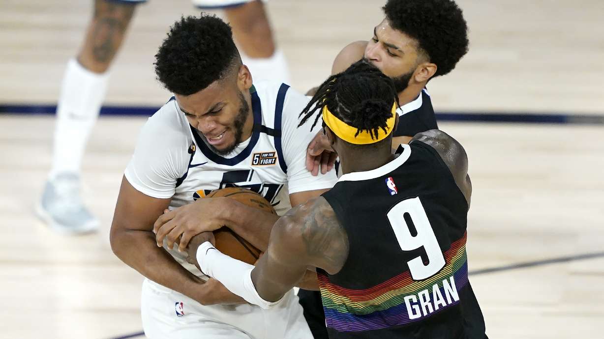 Utah Jazz's Juwan Morgan, left, scrambles for the ball with Denver Nuggets' Jerami Grant (9) and Jamal Murray during the second half of an NBA basketball first round playoff game, Monday, Aug. 17, 2020, in Lake Buena Vista, Fla