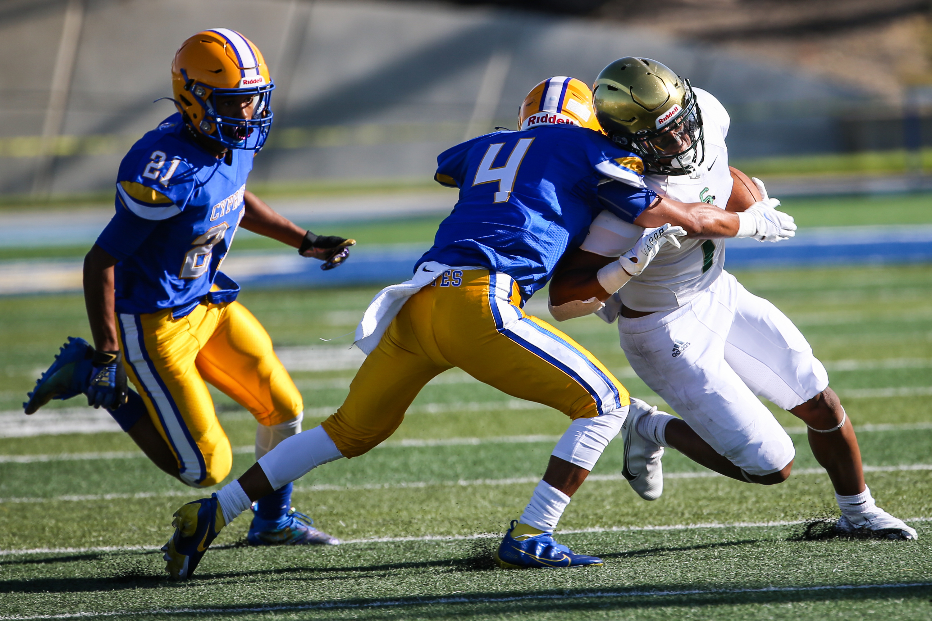 Cyprus’ Adrian Banuelos (4) attempts to stop Snow Canyon’s Bretton Stone (1) with Cary Butler (21) following behind during a high school football game at Cyprus High School in Magna on Friday, Aug. 14, 2020.