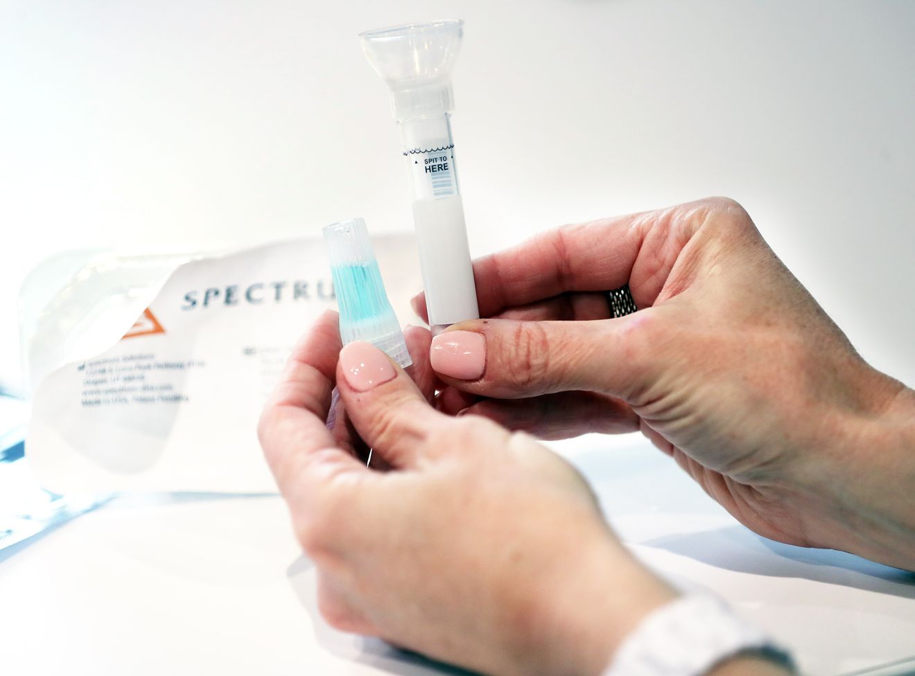Leslie Titus Bryant, director of marketing and brand, holds a completed SDNA-1000 saliva collection device for COVID-19 testing at Spectrum Solutions in Draper on Monday, Aug. 17, 2020.