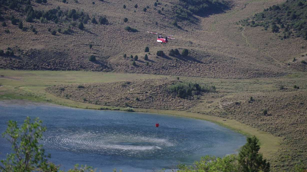 A firefighting helicopter is seen picking up water to drop on the Cowboy Fire near Salina on Tuesday, August 18, 2020.