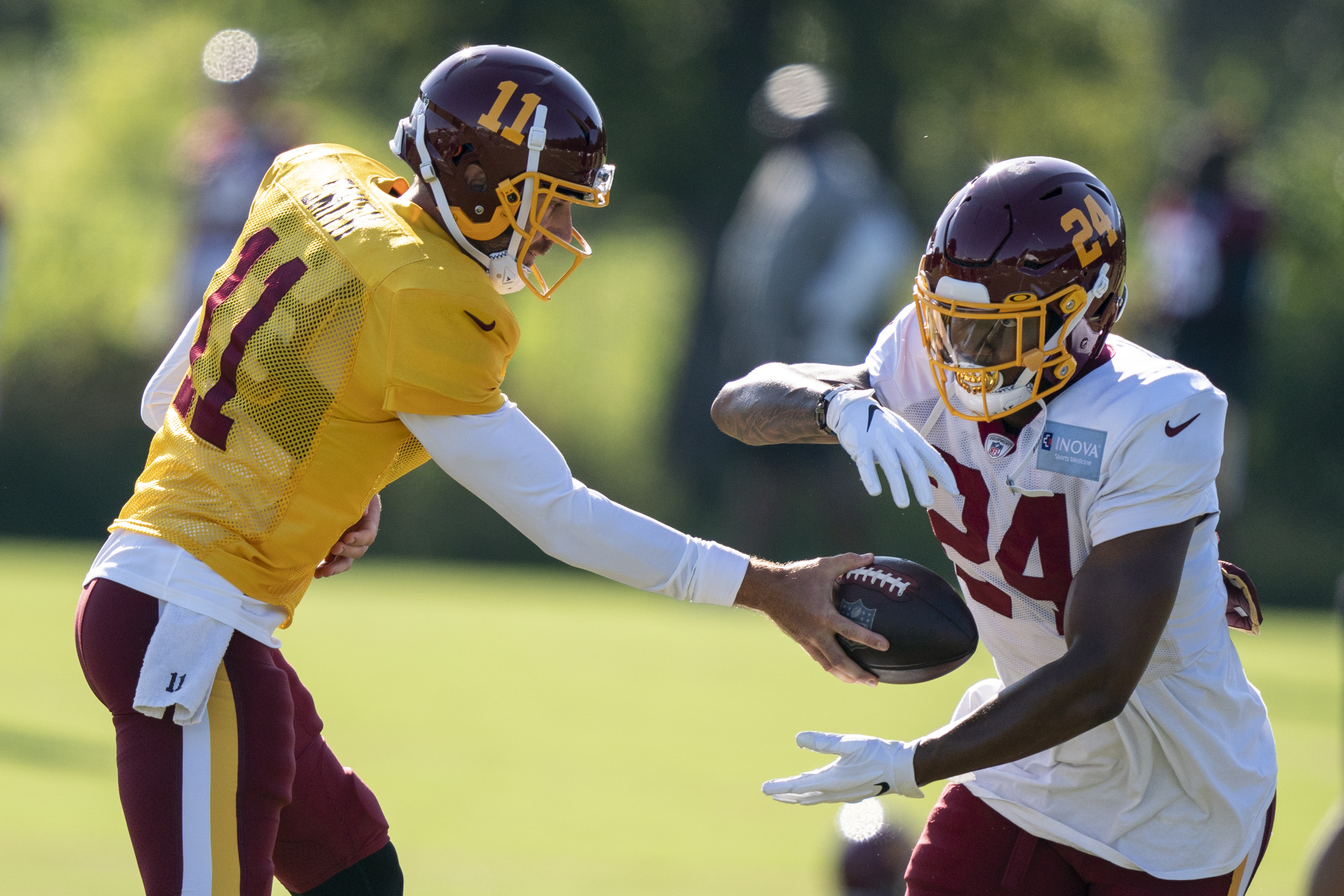 Washington quarterback Alex Smith (11) hands the ball off to running back Antonio Gibson (24) during practice at the team's NFL football training facility, Tuesday, Aug. 18, 2020, in Ashburn, Va.