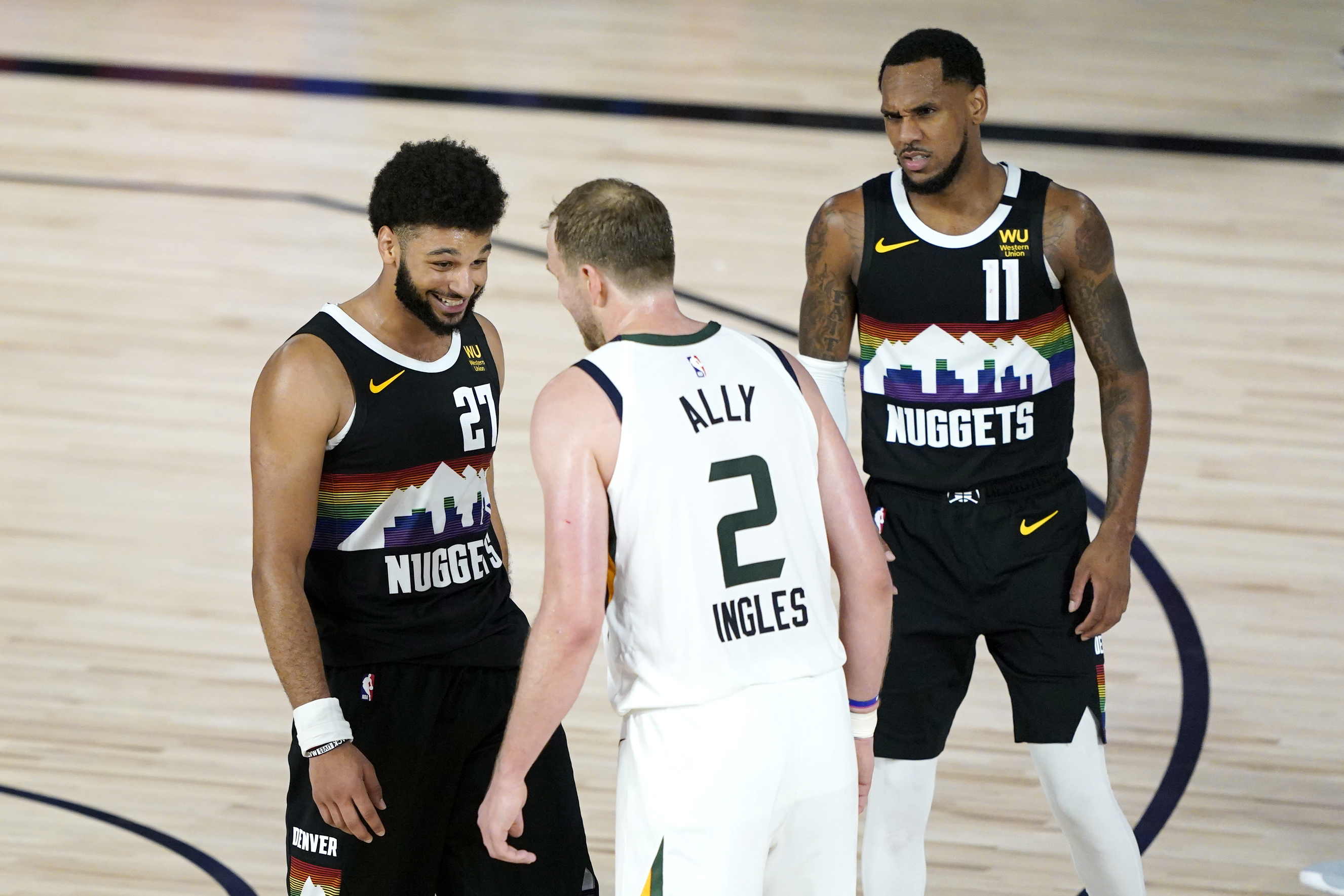 Denver Nuggets' Jamal Murray (27) and Utah Jazz's Joe Ingles (2) converse while Nuggets' Michael Porter Jr., not visible, prepares to take a freethrow during overtime in an NBA basketball first round playoff game, Monday, Aug. 17, 2020, in Lake Buena Vista, Fla. Nuggets' Monte Morris (11) looks on. The Nuggets won 135-125 in overtime.