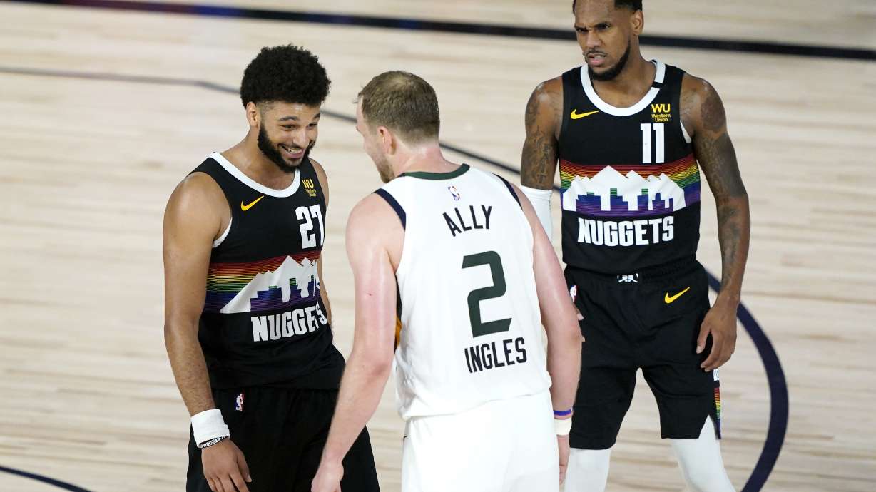 Denver Nuggets' Jamal Murray (27) and Utah Jazz's Joe Ingles (2) converse while Nuggets' Michael Porter Jr., not visible, prepares to take a freethrow during overtime in an NBA basketball first round playoff game, Monday, Aug. 17, 2020, in Lake Buena Vista, Fla. Nuggets' Monte Morris (11) looks on. The Nuggets won 135-125 in overtime.