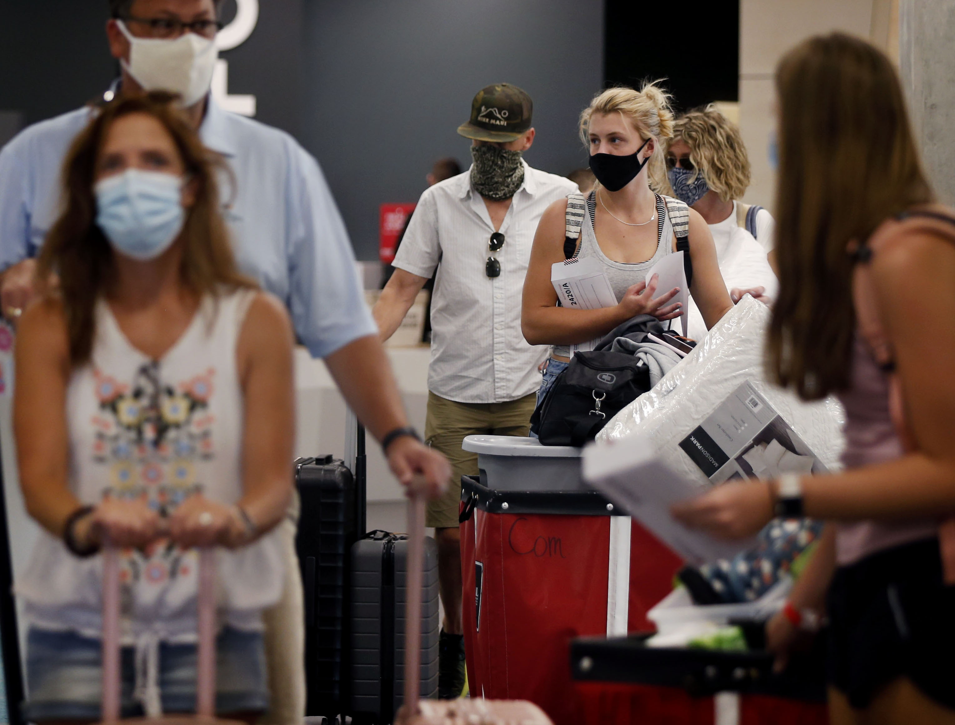 Parents and their children wait for an elevator as they move belongings into Kahlert Village at the University of Utah in Salt Lake City on Thursday, Aug. 20, 2020.