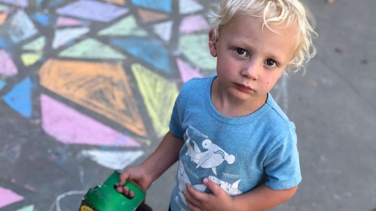 Arianne Brown's 2-year-old son, Ash, holds a box of sidewalk chalk.