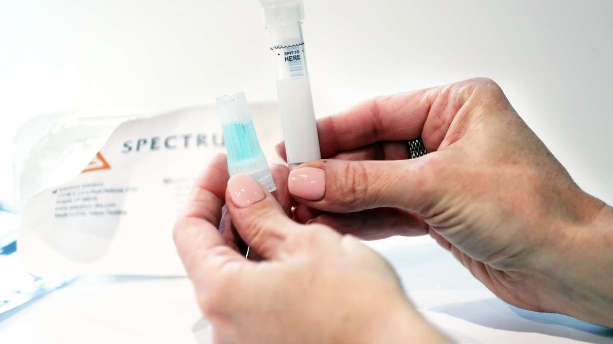 Leslie Titus Bryant, director of marketing and brand, holds a completed SDNA-1000 saliva collection device for COVID-19 testing at Spectrum Solutions in Draper on Monday, Aug. 17, 2020.