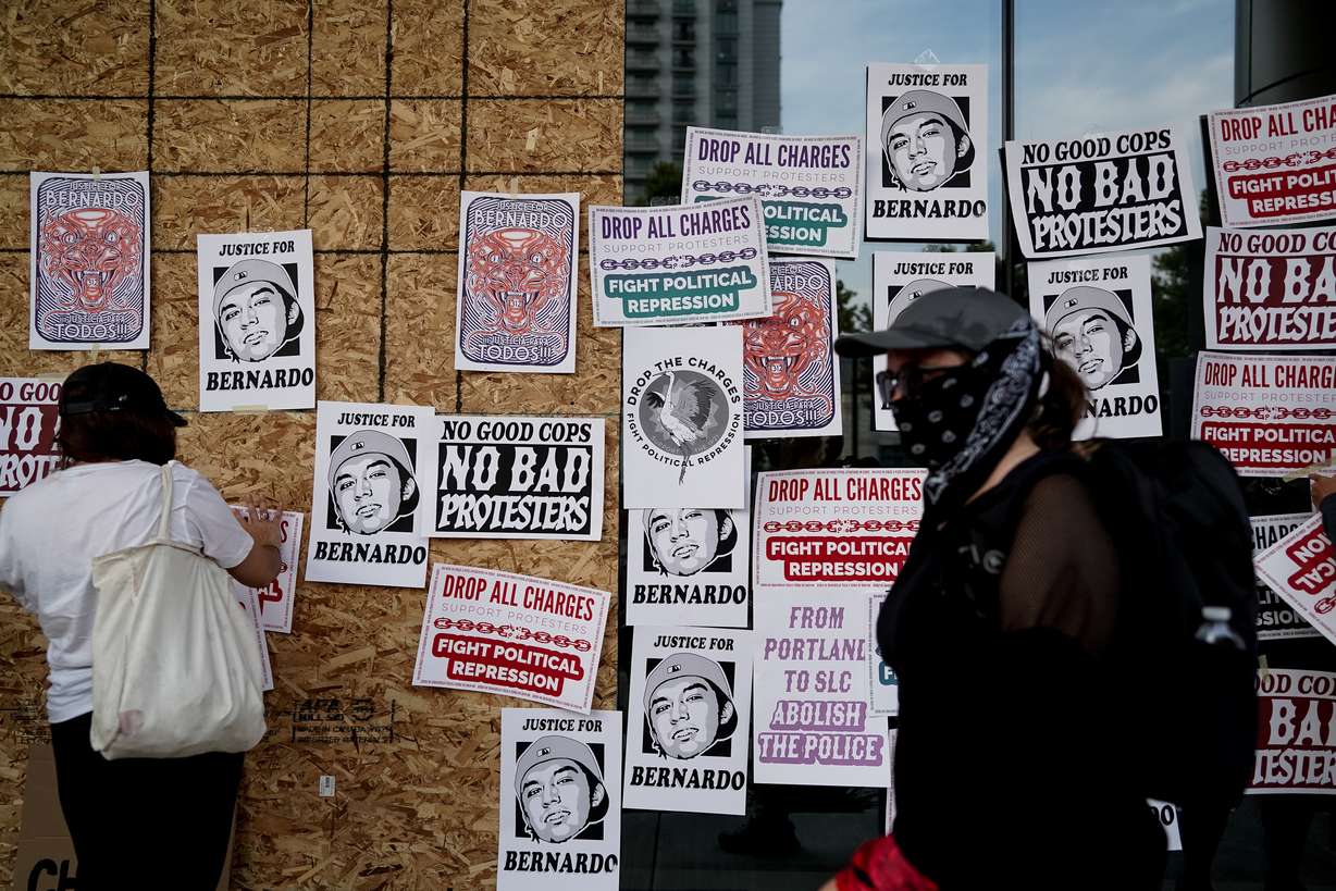 Anti-racism protesters paste flyers on the windows of the District Attorney’s Office building in Salt Lake City on Saturday, Aug. 22, 2020. The protesters called for charges against those involved in the July 9 protests outside District Attorney Sim Gill’s office to be dropped.