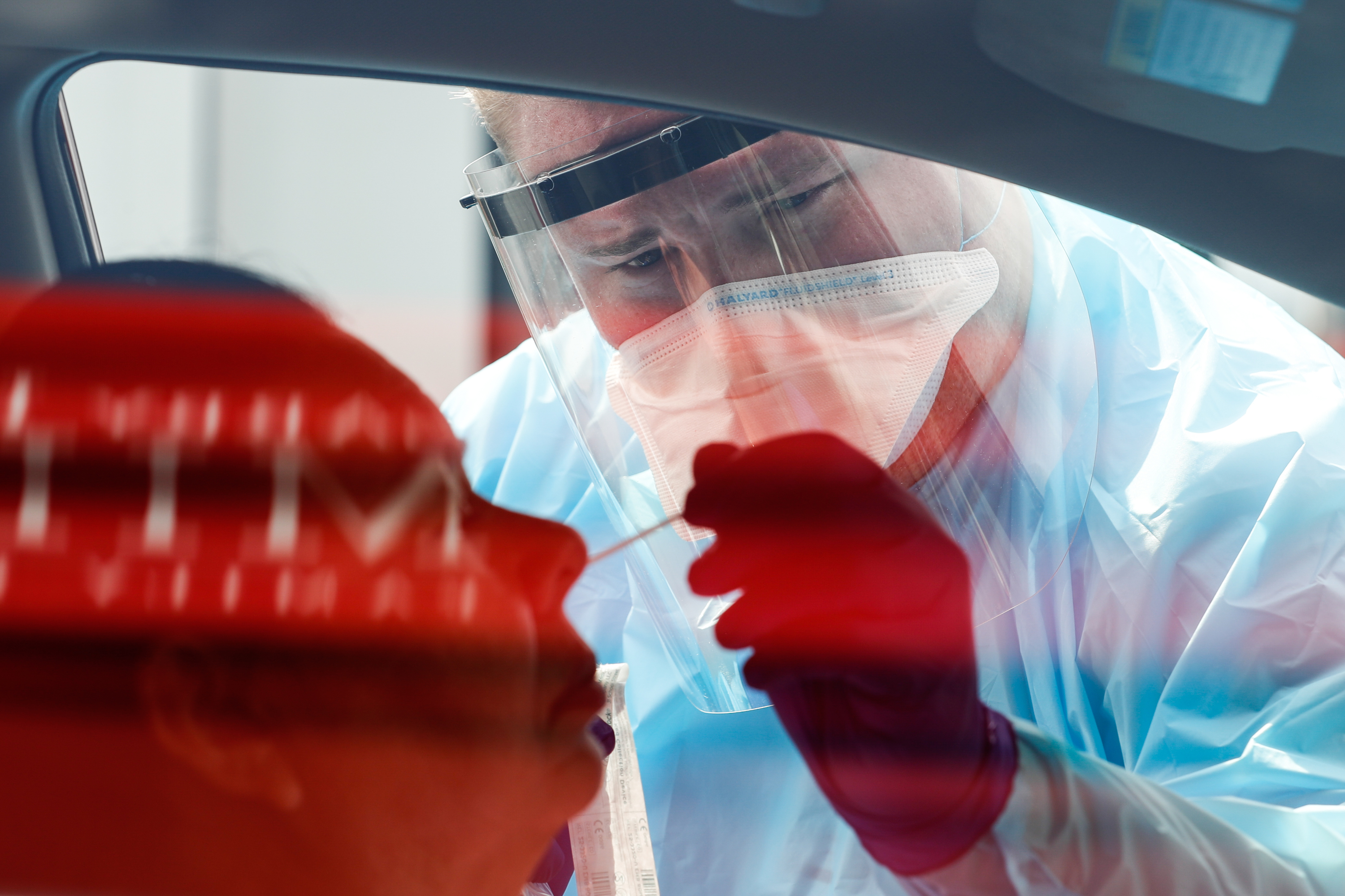 Dakota Sliva administers a COVID-19 test to a patient as University of Utah Health's Wellness Bus visits the Sorenson Multicultural Center in Salt Lake City on Thursday, Aug. 20, 2020.