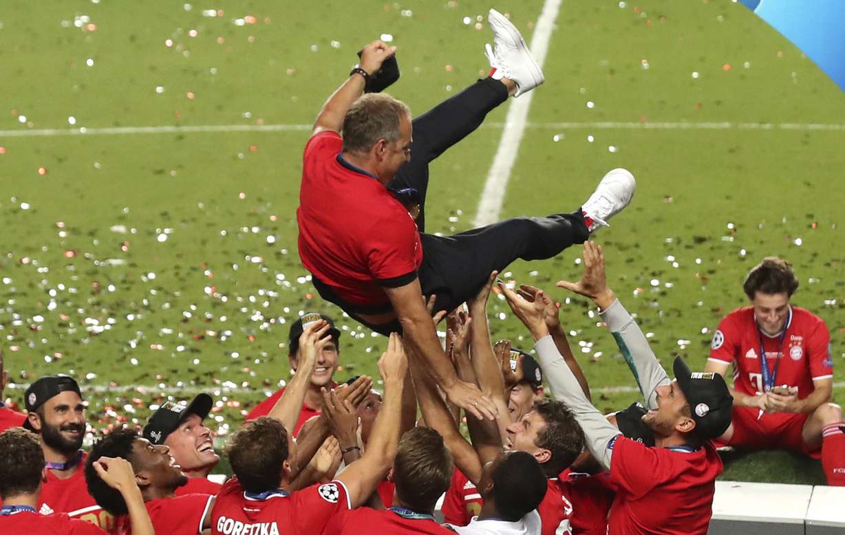 Bayern's head coach Hans-Dieter Flick is tossed in the air by his players as they celebrate after winning the Champions League final soccer match between Paris Saint-Germain and Bayern Munich at the Luz stadium in Lisbon, Portugal, Sunday, Aug. 23, 2020.