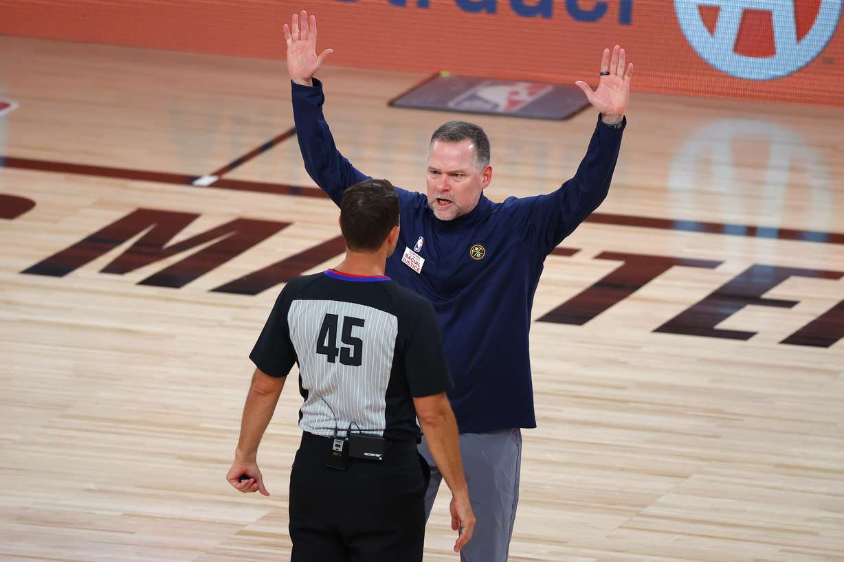 Denver Nuggets coach Michael Malone of the Denver Nuggets argues with referee Brian Forte during the third quarter against the Utah Jazz in Game 4 of an NBA basketball first-round playoff series, Sunday, Aug. 23, 2020, in Lake Buena Vista, Fla.