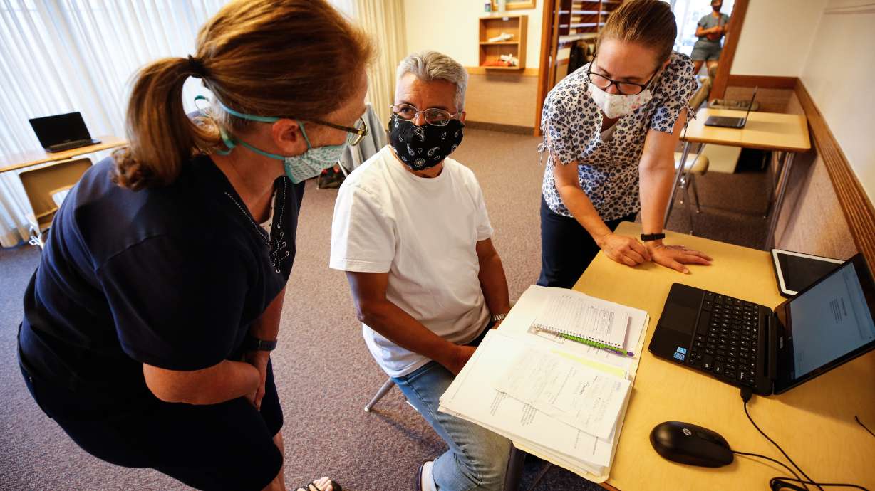 Ann Syphus, left, and Clarrisa Bartholomew, right, help Francisco Terreros use a laptop at Rose Park Stake Center of The Church of Jesus Christ of Latter-day Saints in Salt Lake City on Thursday, Aug. 6, 2020. It is part of a program for people in the community who don't have internet access in their home.