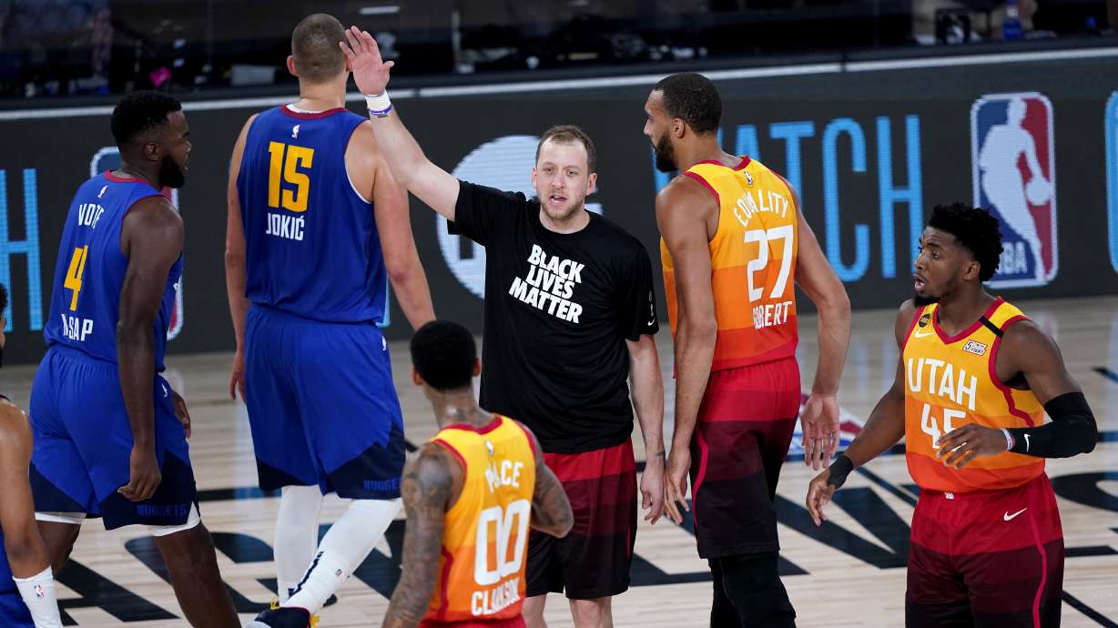 Utah Jazz's Joe Ingles, center, cheers as teammates Rudy Gobert (27) and Jordan Clarkson (00) and Denver Nuggets' Nikola Jokic (15) and Paul Millsap (4) walk to their benches during the second half of an NBA basketball first round playoff game Friday, Aug. 21, 2020, in Lake Buena Vista, Fla.