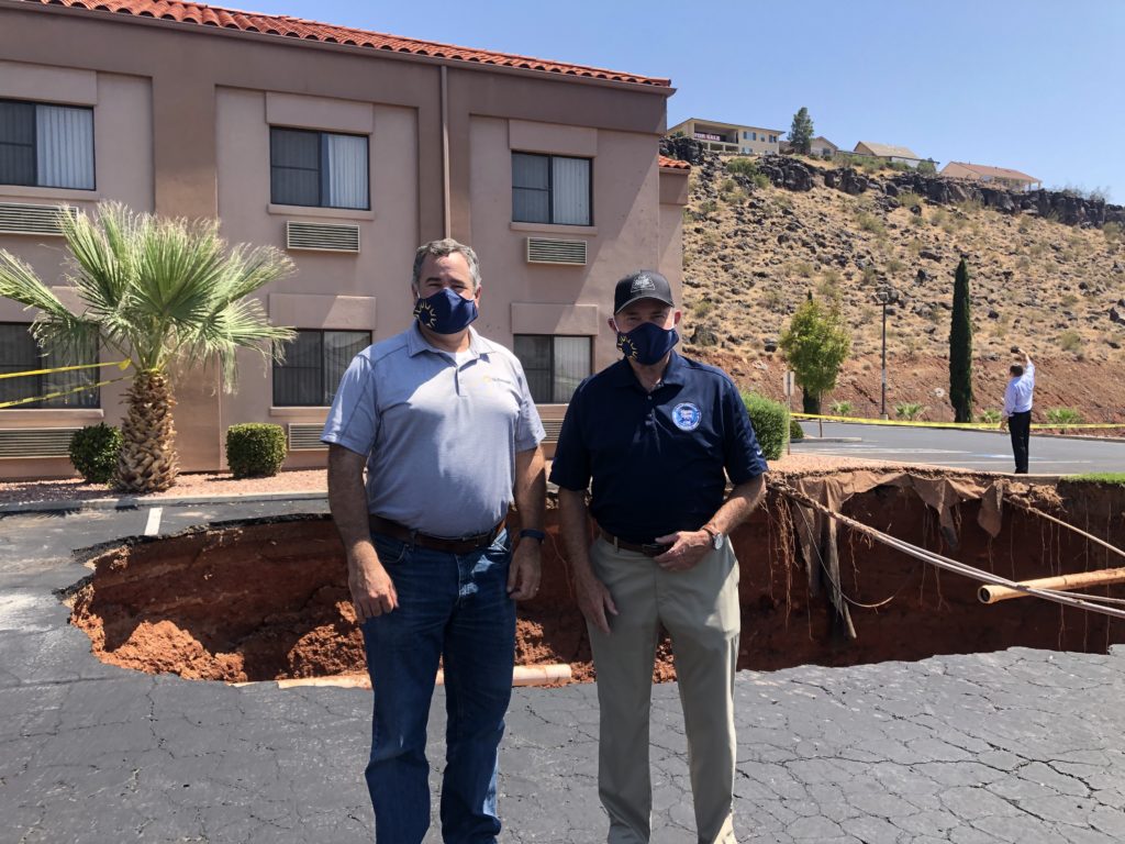 L-R: St. George Mayor Jon Pike and Gov. Gary Herbert pause for a photo in front of a large sinkhole that opened up near the Ramada Inn, St. George, Utah, Aug. 24, 2020 