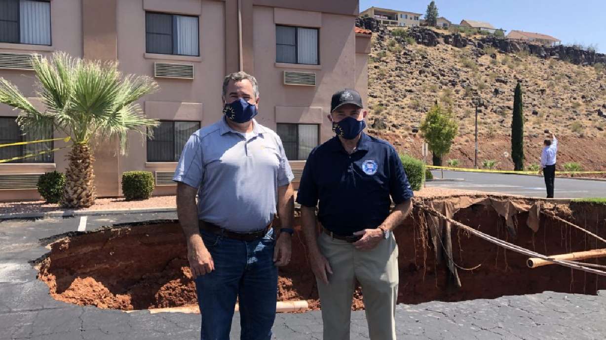L-R: St. George Mayor Jon Pike and Gov. Gary Herbert pause for a photo in front of a large sinkhole that opened up near the Ramada Inn, St. George, Utah, Aug. 24, 2020