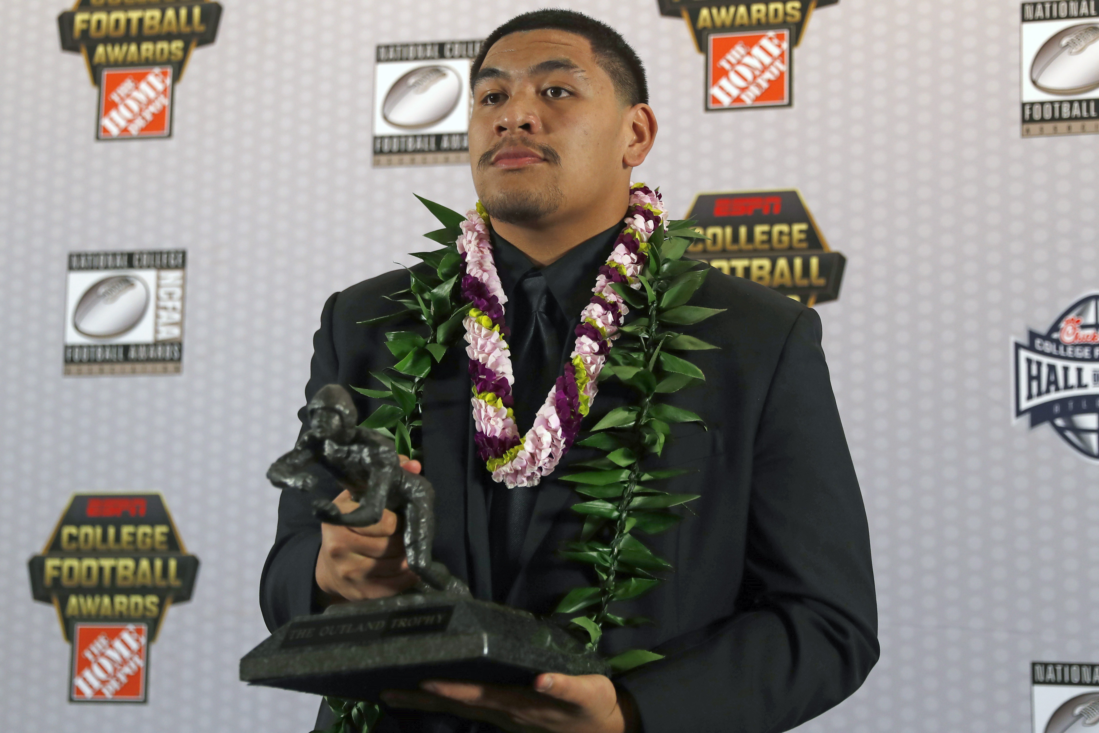 FILE - In this Dec. 12, 2019, file photo, Oregon's Penei Sewell poses with Outland Trophy for being the nation's best interior lineman, in Atlanta. Penn State linebacker Micah Parsons and Oregon tackle Penei Sewell are among 11 players selected to The Associated Press preseason All-America first-team, Tuesday, Aug. 25, 2020, who are not slated to play this fall.