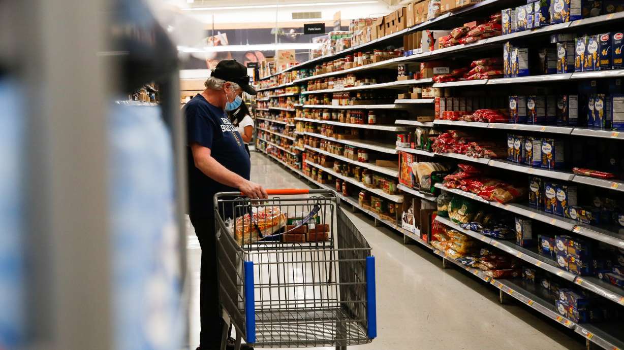 A customer shops for groceries at Walmart in Orem on Monday, July 20, 2020, the first day the retail giant required all customers to wear a face masks to help slow the spread of COVID-19.
