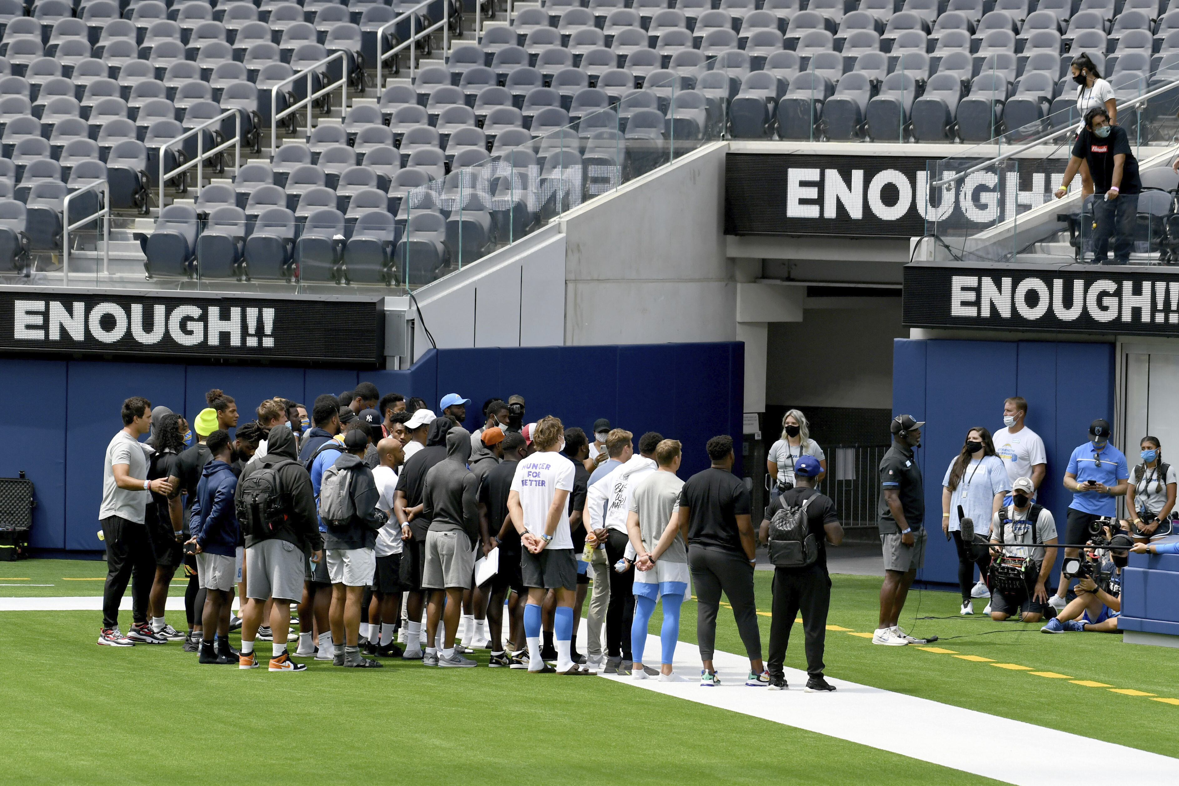 Los Angeles Chargers head coach Anthony Lynn, with players behind him, talks to the media about the cancelation of practice and a scrimmage at SoFi Stadium in Inglewood, Calif., Thursday, Aug. 27, 2020. The team canceled practice due to the recent shooting of Jacob Blake. Lynn canceled practice after his players held a wide-ranging conversation in the locker room spurred by the shooting of Blake, a Black man, in Wisconsin last weekend.