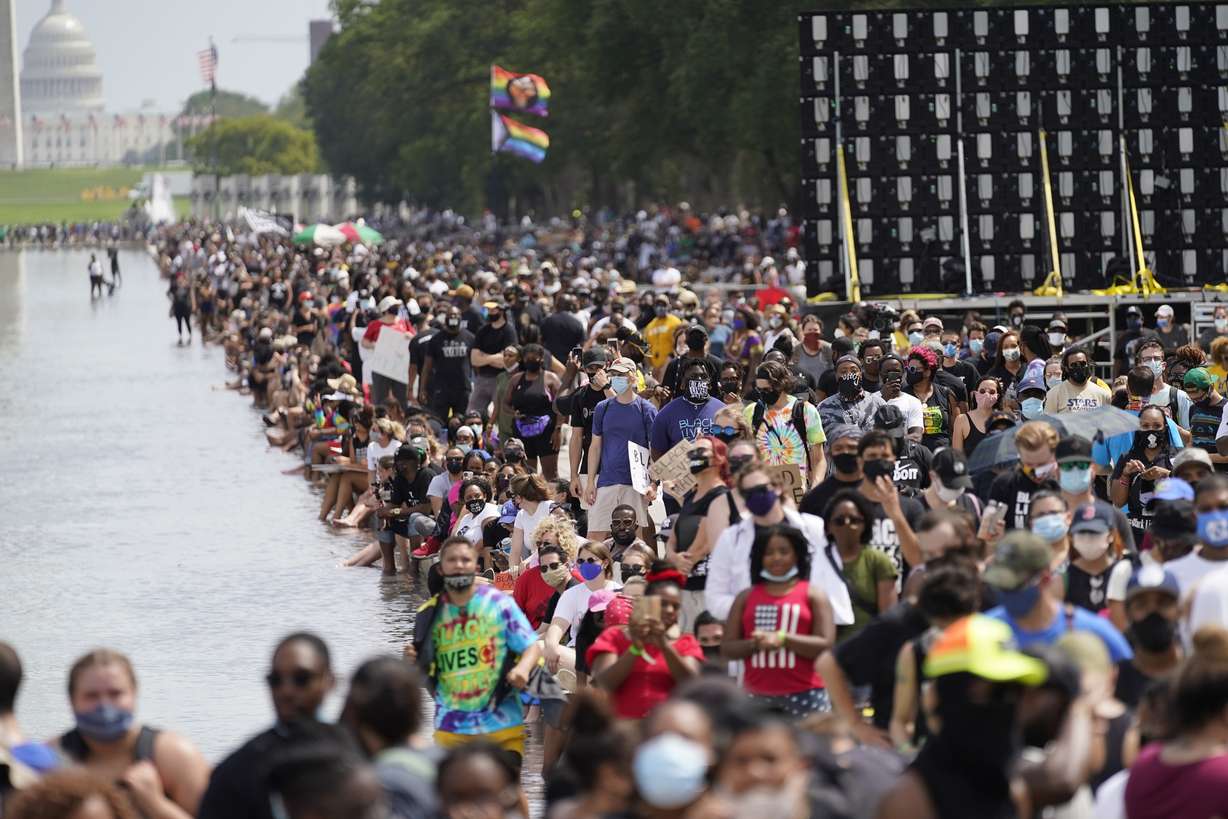 People participate in the March on Washington, Friday, Aug. 28, 2020, at the Lincoln Memorial in Washington, on the 57th anniversary of the Rev. Martin Luther King Jr.'s "I Have A Dream" speech. Behind is the U.S. Capitol.
