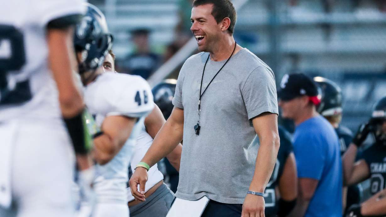 Head coach Eric Kjar warms up with players as Corner Canyon football hosts its annual intrasquad scrimmage in Draper on Friday, Aug. 7, 2020.