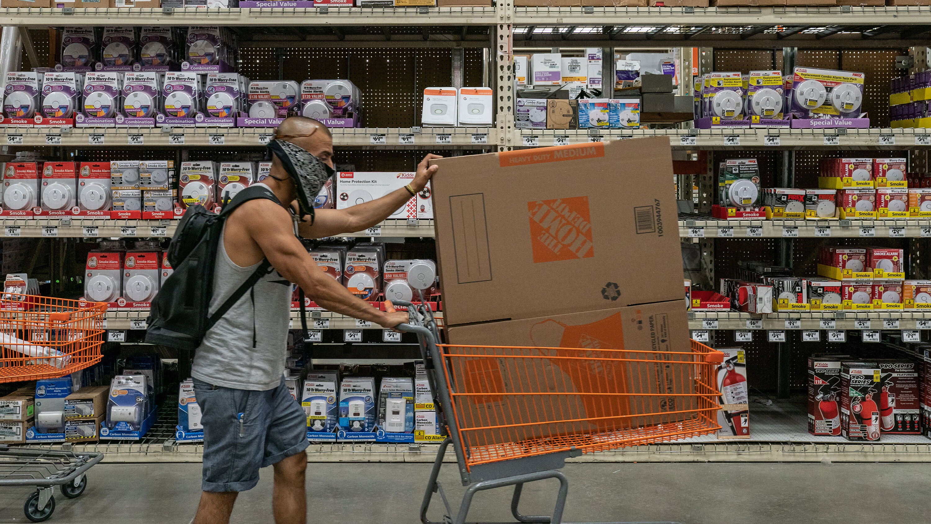 A shopper wearing a protective mask pushes a cart at a Home Depot Inc. store in Jersey City, New Jersey, U.S., on Friday, Aug. 14, 2020. Home Depot is having a busy summer, with a 23% revenue jump in the quarter that ended in July.