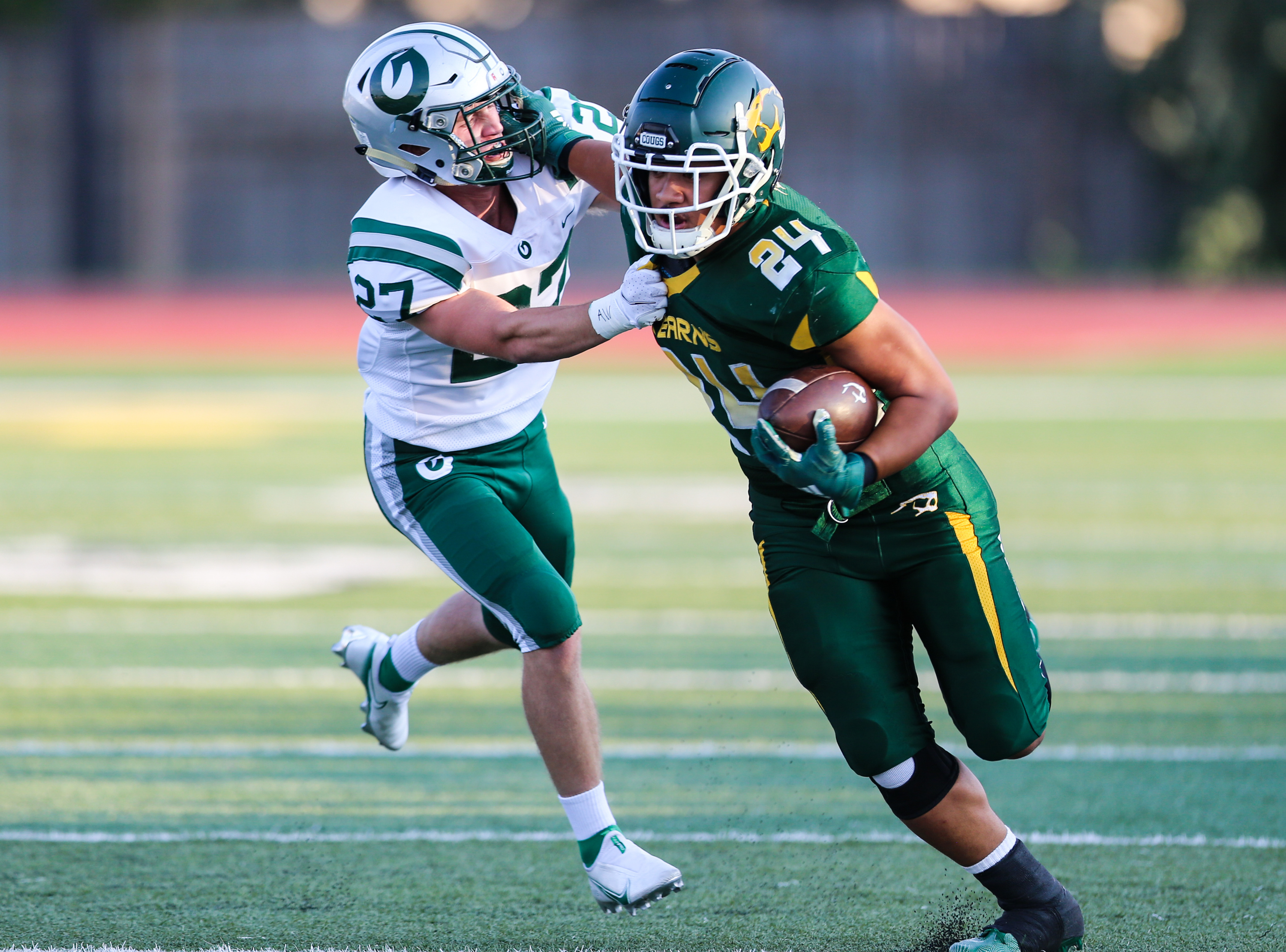 Kearns' Naki Leha (24) carries the ball against Olympus' Jordan Allred (27) during a high school football game at Kearns High School in Kearns on Friday, Aug. 28, 2020.