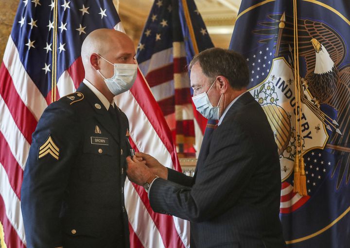 Gov. Gary Herbert pins the Utah Medal of Valor on Sgt. Chasen Brown, a service member of the Utah National Guard, in the Gold Room at the Utah State Capitol on Tuesday, Sept. 1, 2020.