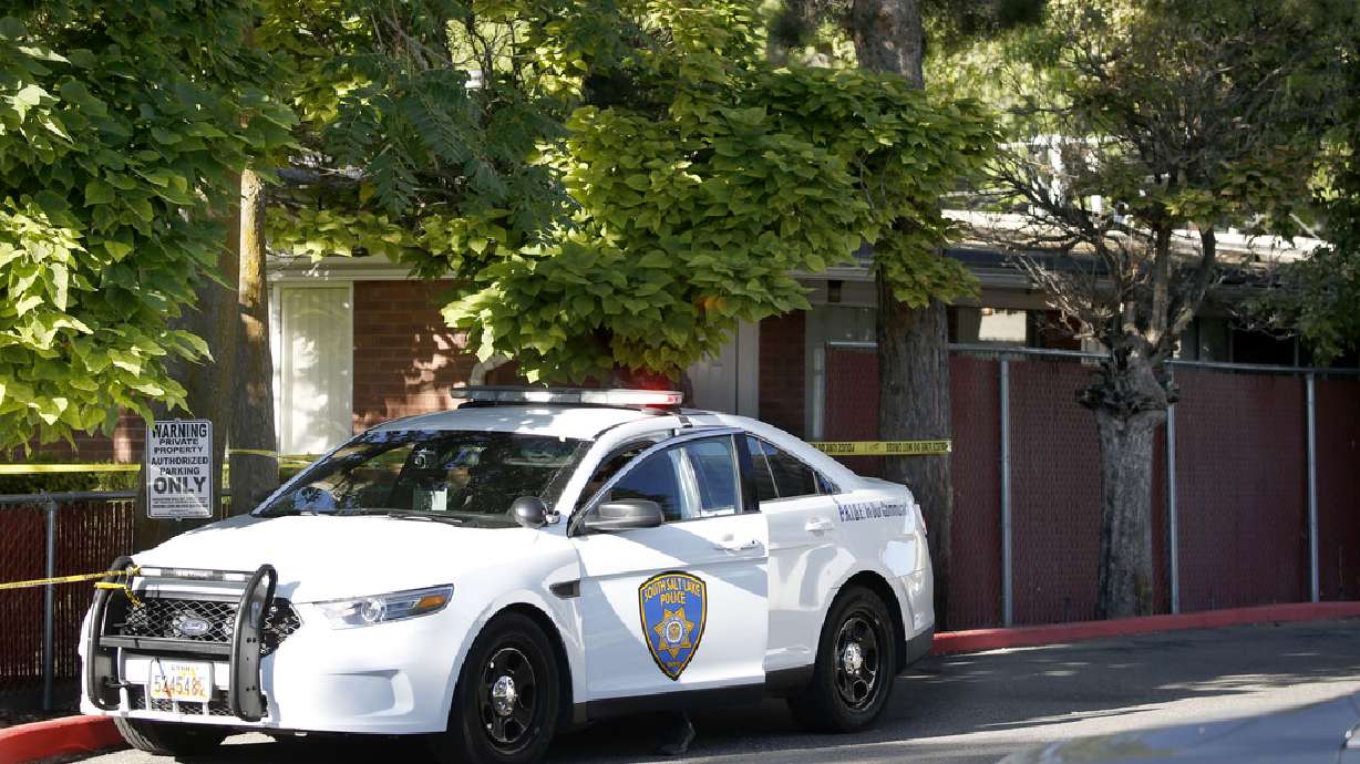 A South Salt Lake police officer sits in a patrol car at the scene of a stabbing in South Salt Lake on Wednesday, Sept. 2, 2020. A 69-year-old suspect is in custody after a person was found dead inside an apartment at 2880 S. 200 East.