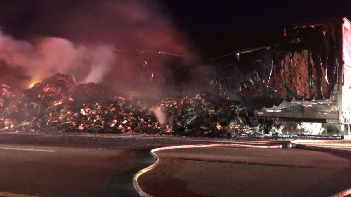 The refrigerated food contents spill out what was the refrigerated trailer of a semitractor-trailer that burst into flames late Wednesday alongside southbound Interstate 15 near Toquerville, Utah, Sept. 2, 2020.