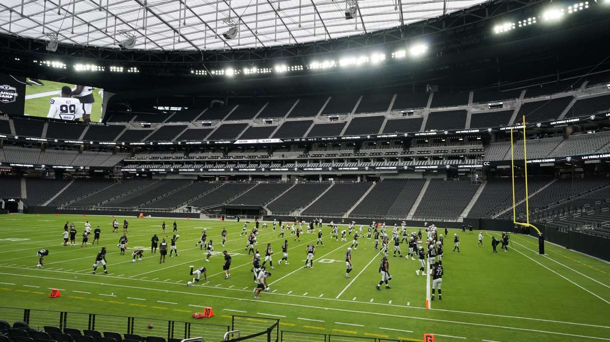 Las Vegas Raiders players warms up during an NFL football training camp practice at Allegiant Stadium, Friday, Aug. 28, 2020, in Las Vegas. The stadium that will host BYU's season opener Sept. 4 against Arizona will require masks for all fans in attendance.