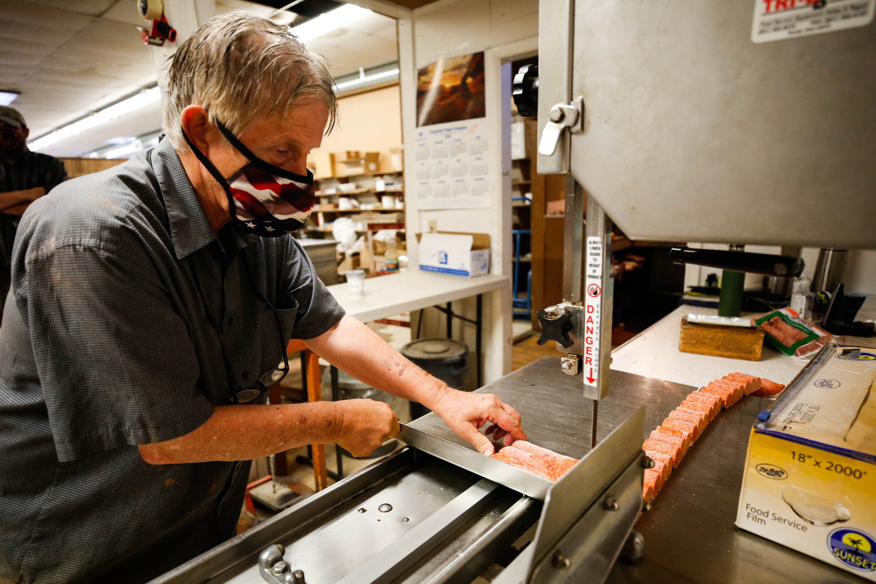 Danny Colosimo cuts sausages into pieces at Colosimo's Standard Market in Magna on Friday, Sept. 4, 2020.