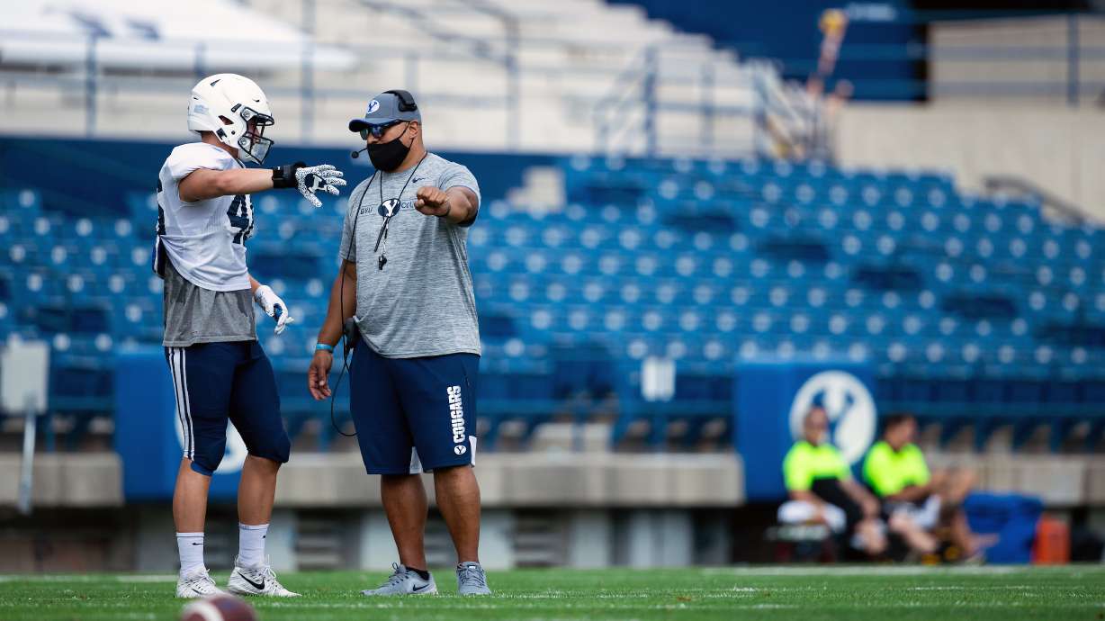 BYU coach Kalani Sitake speaks with linebacker Drew Jensen during a team scrimmage, Aug. 20, 2020 at LaVell Edwards Stadium in Provo.