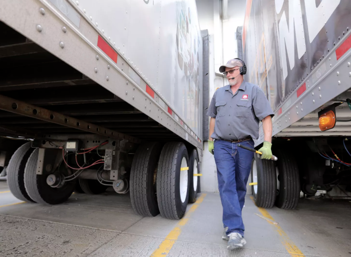 Dusty Senn, Associated Foods truck driver, walks between two trailers after hooking up a set of trailers outside of the Associated Foods distribution warehouse in Farr West, Weber County, on Wednesday, Aug. 19, 2020.