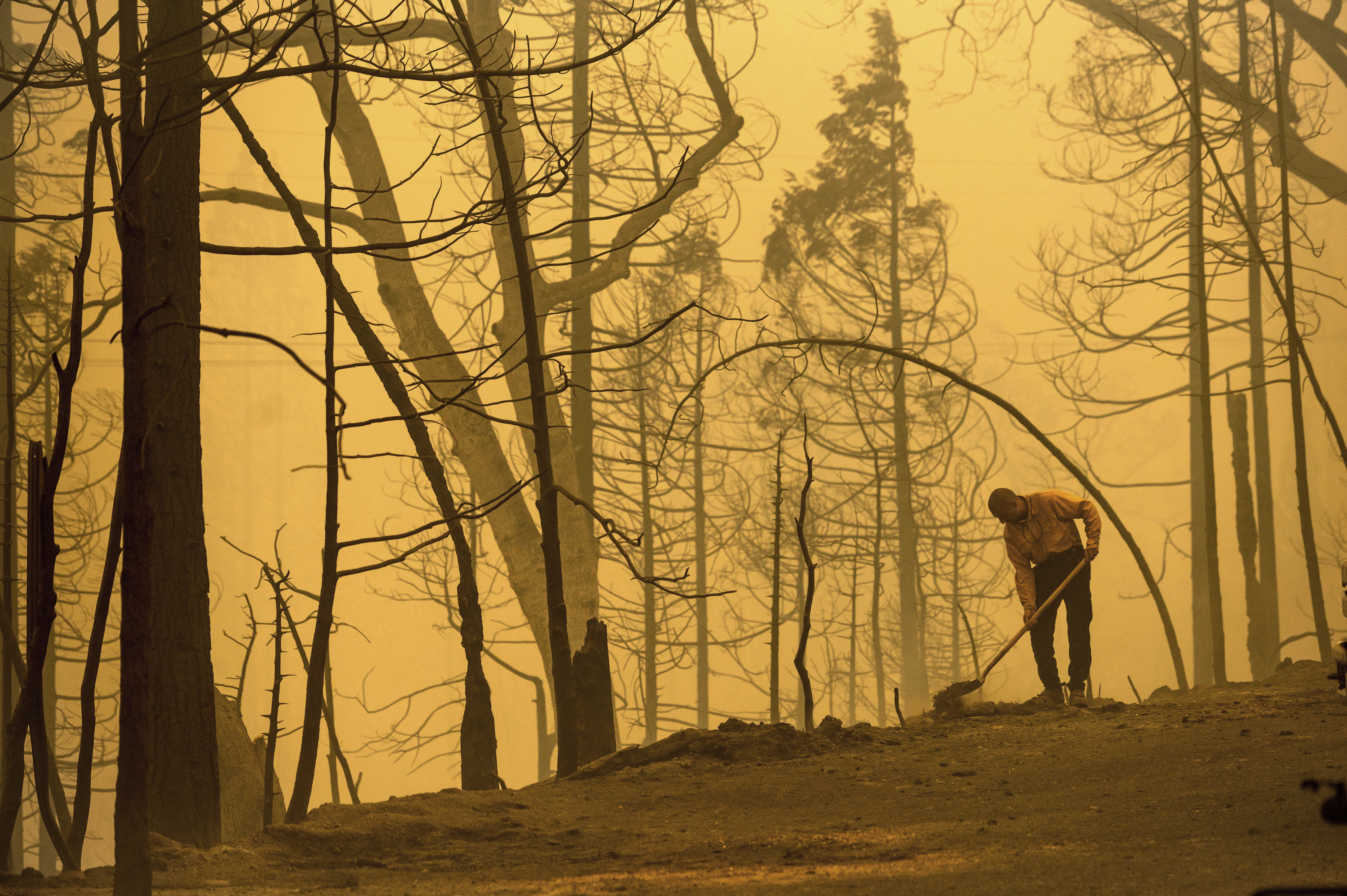Firefighter Dan Robles extinguishes a hot spot while battling the Creek Fire on Tuesday, Sept. 8, 2020, in Fresno County, Calif.
