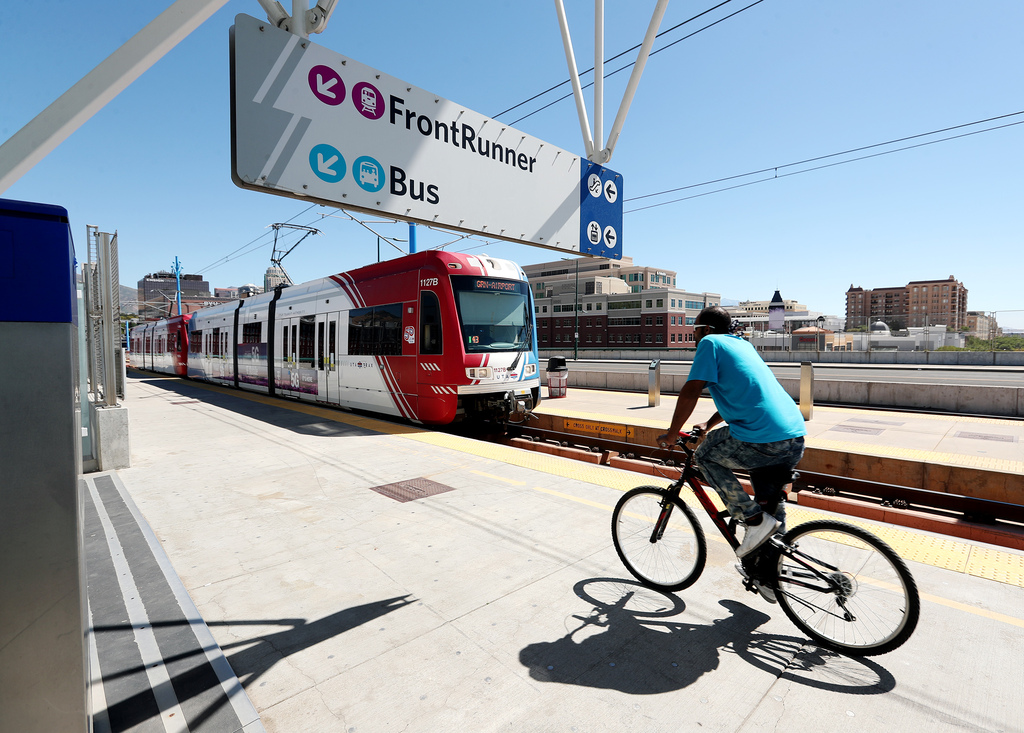 TRAX light-rail train pulls into the North Temple Bridge/Guadalupe Station in Salt Lake City as a cyclist rides past on Sept. 1, 2020. Fares across all Utah Transit Authority services will be waived next month, the agency announced Tuesday.